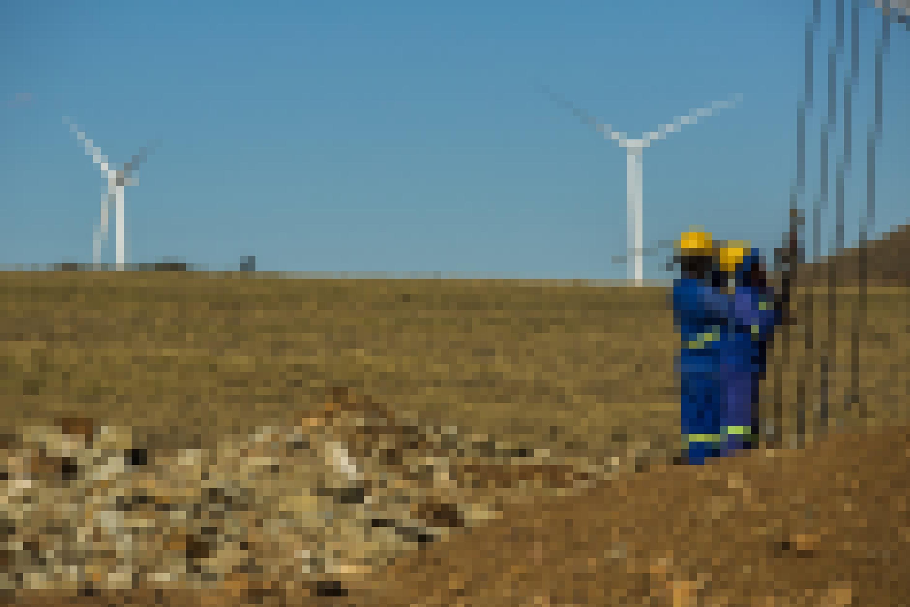 Windfarm in Südafrika mit zwei Arbeitern im Vordergrund