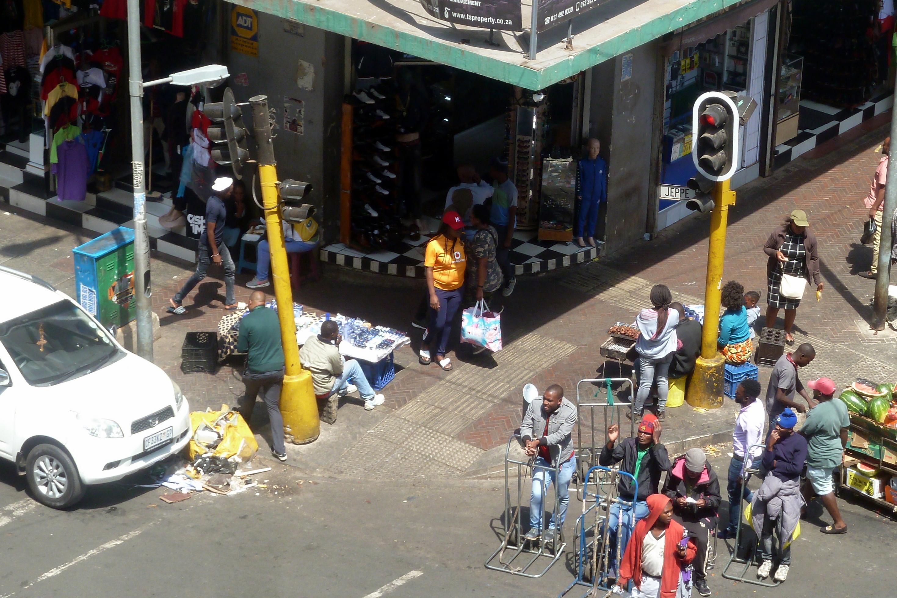 Ein Blick auf eine Straßenkreuzung im Zentrum Johannesburgs, Geschäfte, Händler, Passanten