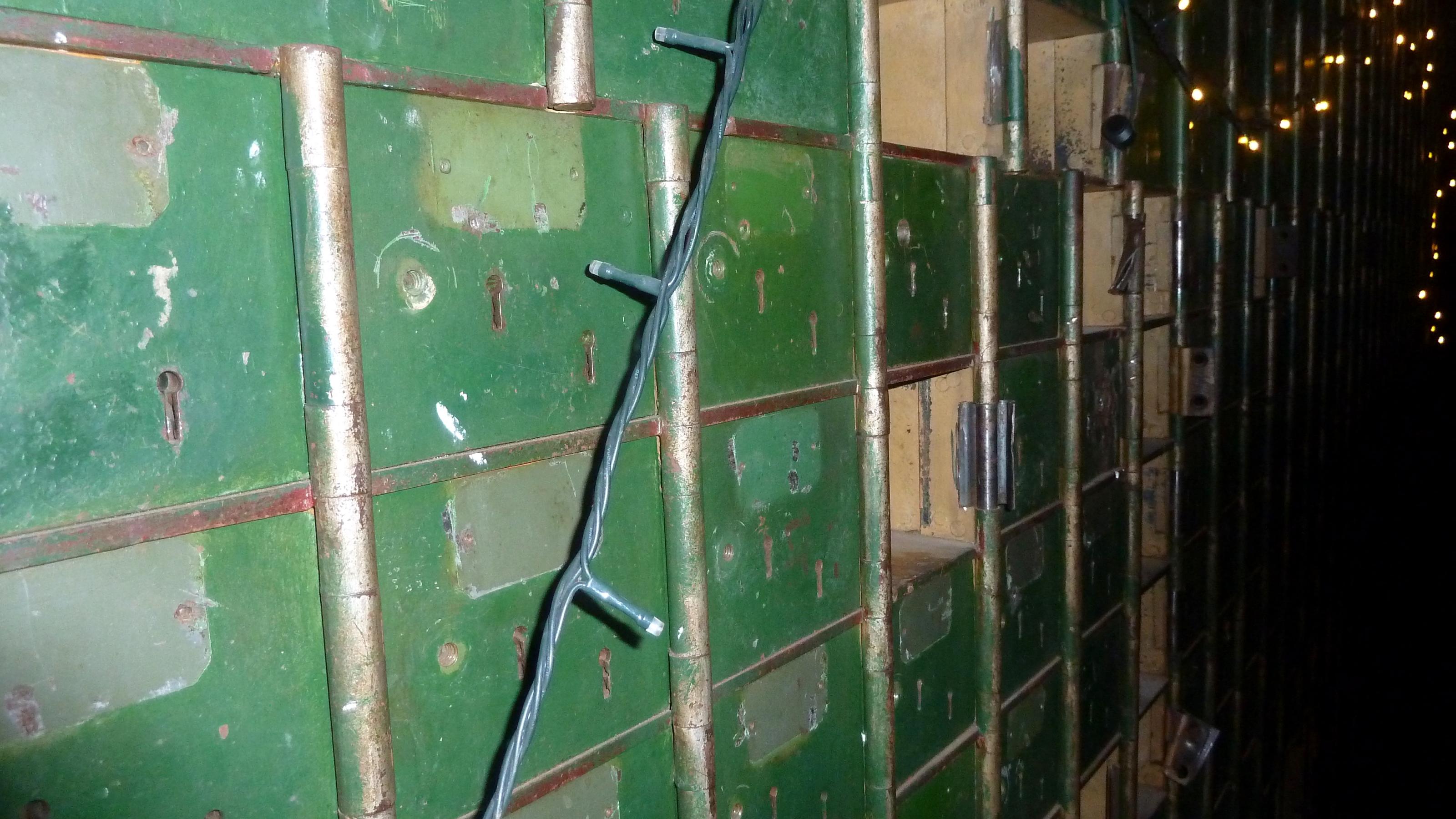 Grüne teils noch geschlossene alte Schliessfächer im Tresorraum, dekoriert mit einer Lichterkette
