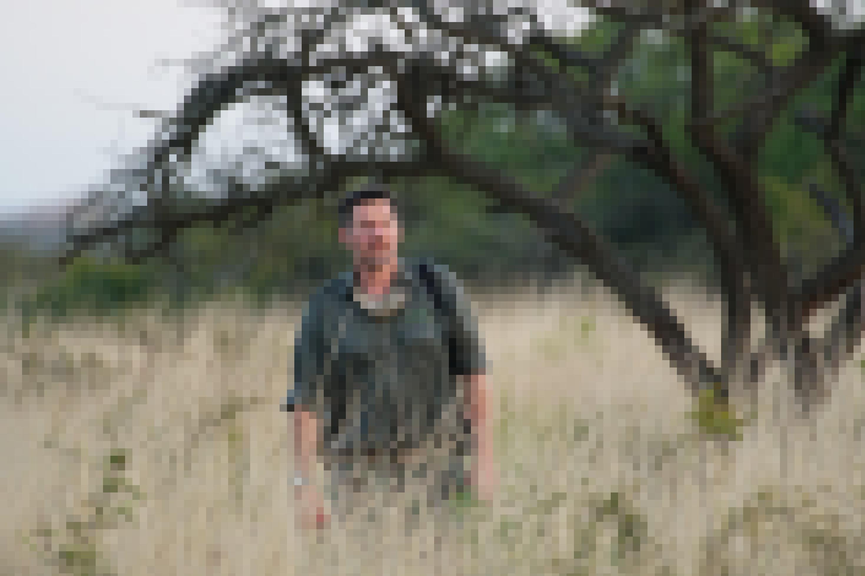 Simon Naylor, der Conservation Manager des Phinda Private Game Reserve, steht in der weiten Buschlandschaft