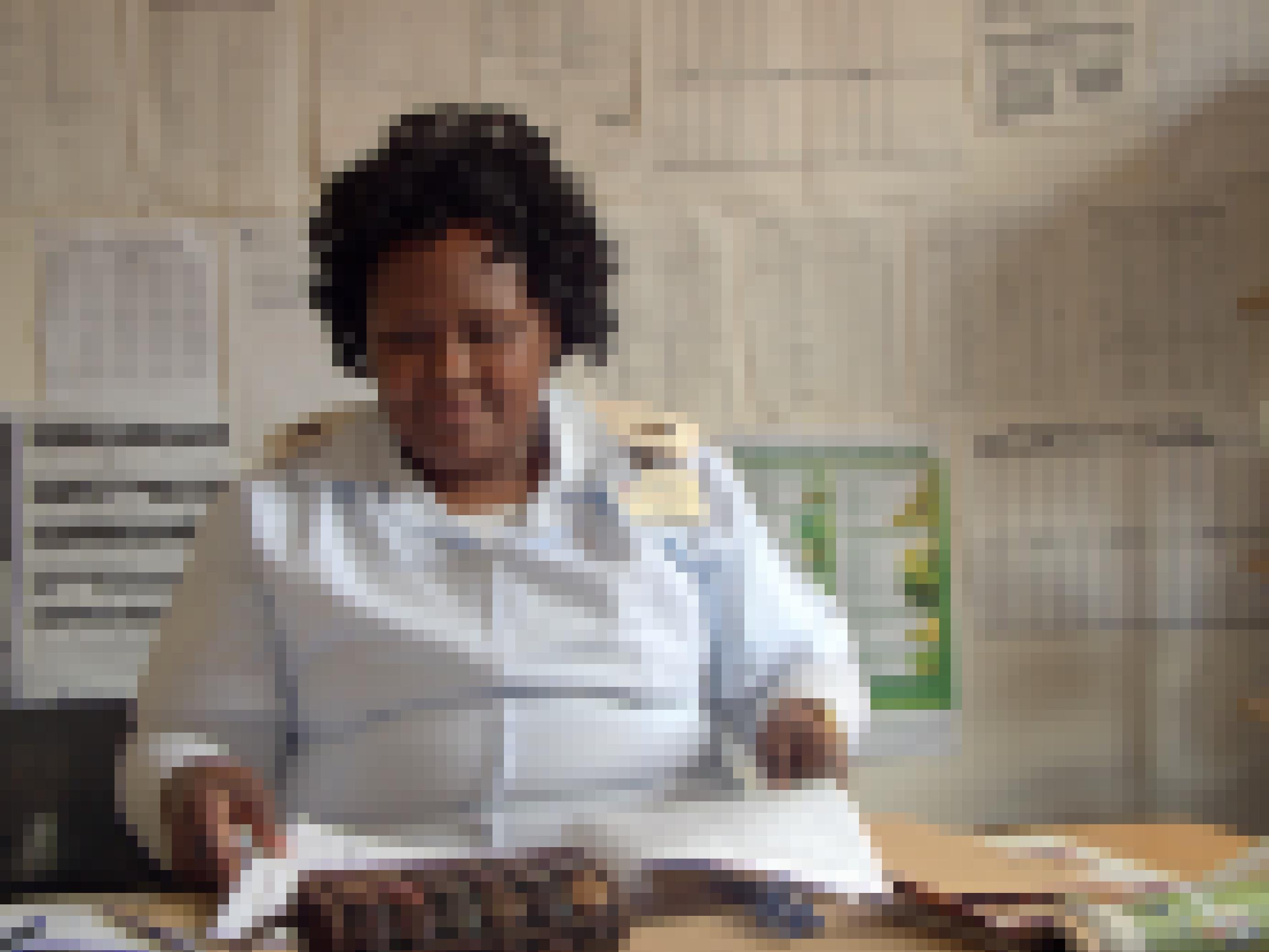 Krankenschwester Edna Waryawa sitzt hinter ihrem Schreibtisch und schaut in eine Patientenakte.