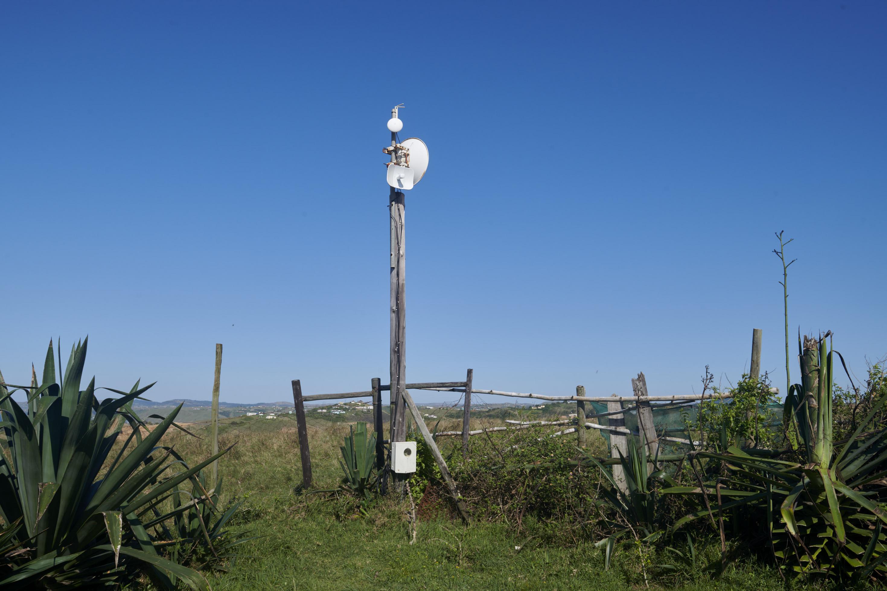 An einem Pfahl vor einem Holzzaun ist die Antenne des Hotspots installiert