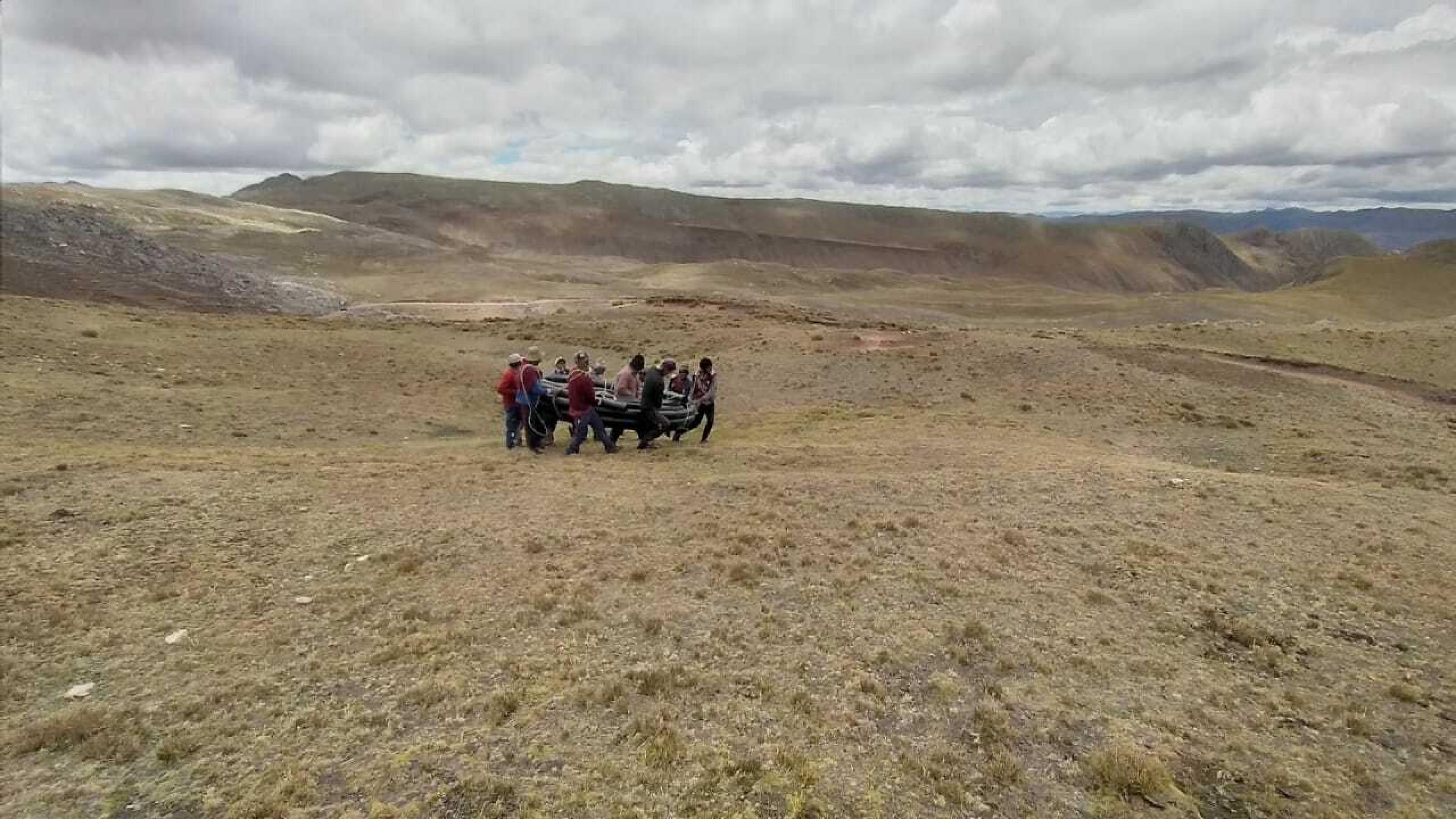 Verdorrte Berglandschaft, Hochebene. Eine Gruppe von Bauern schleppt gemeinsam Wasserleitungen.