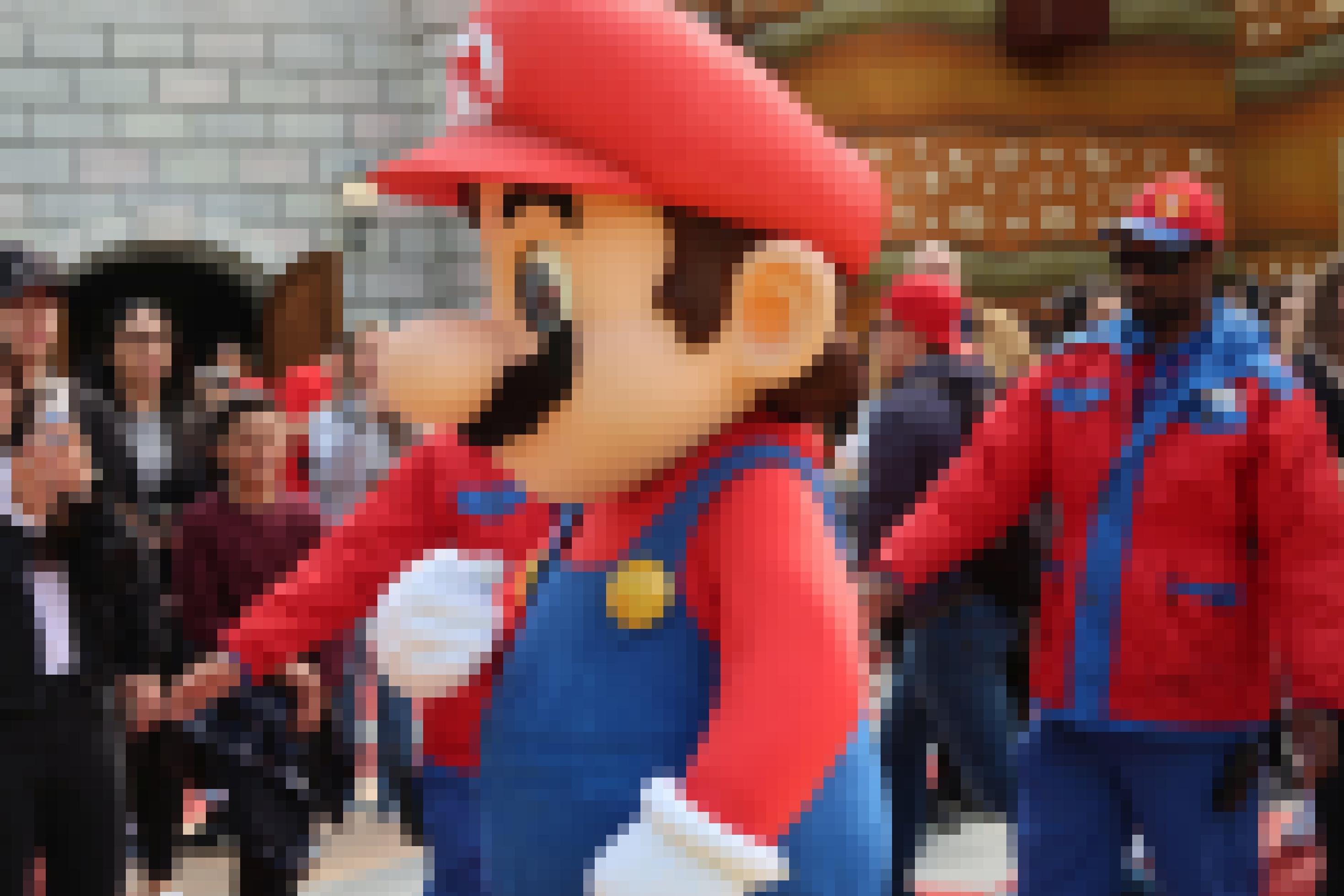 Super Mario im Freizeitpark, eskortiert von Mitarbeitenden