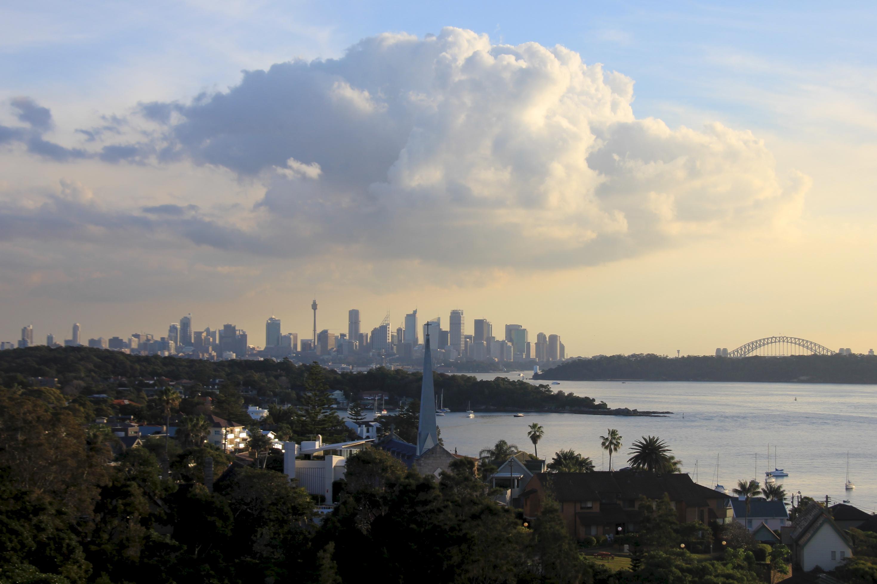 Ein Blick vom Osten der Stadt über den Hafen Richtung Innenstadt, im Hintergrund die Sydney Harbour Bridge.