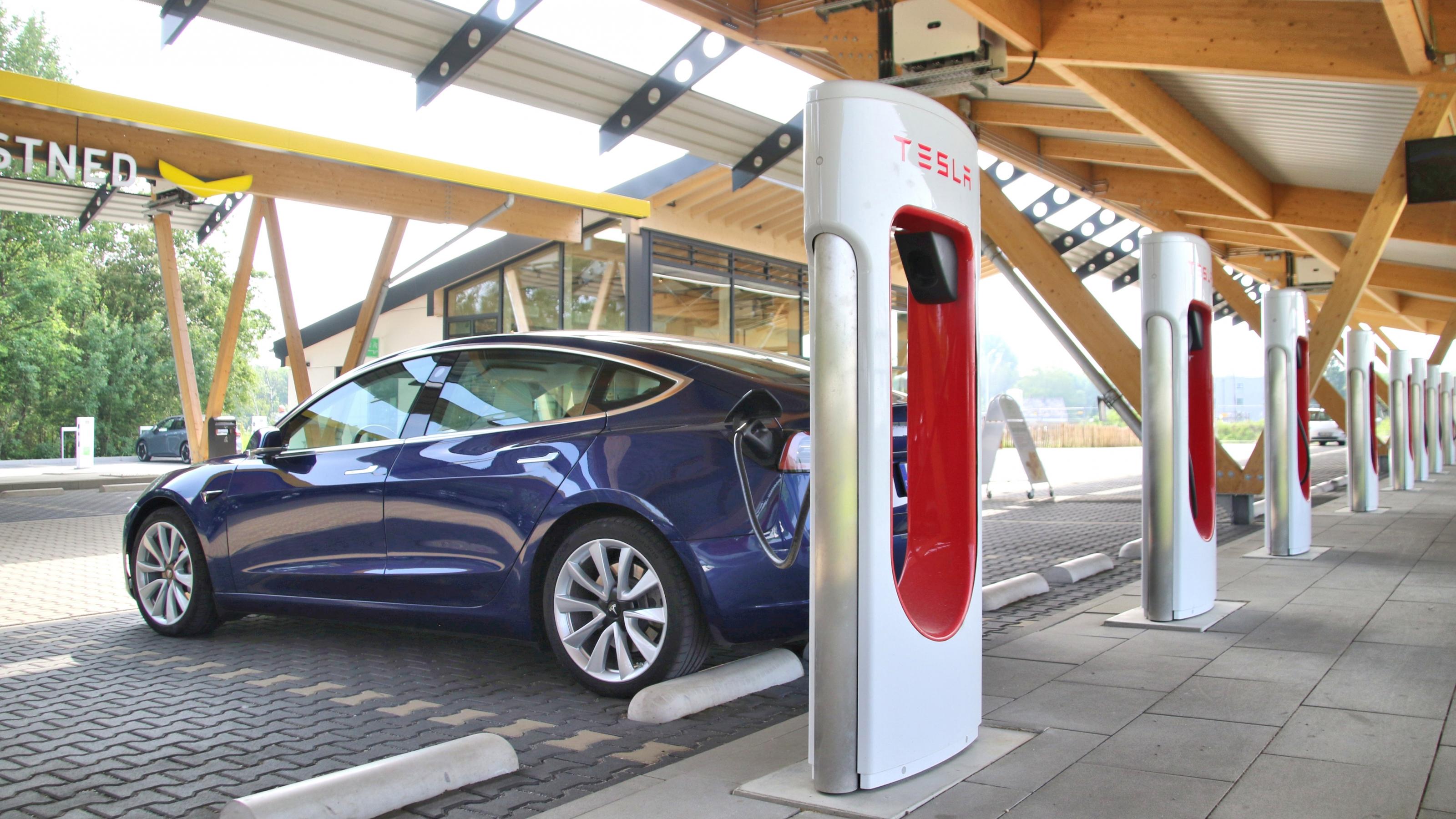 Ein Tesla lädt Strom an einem Supercharger.