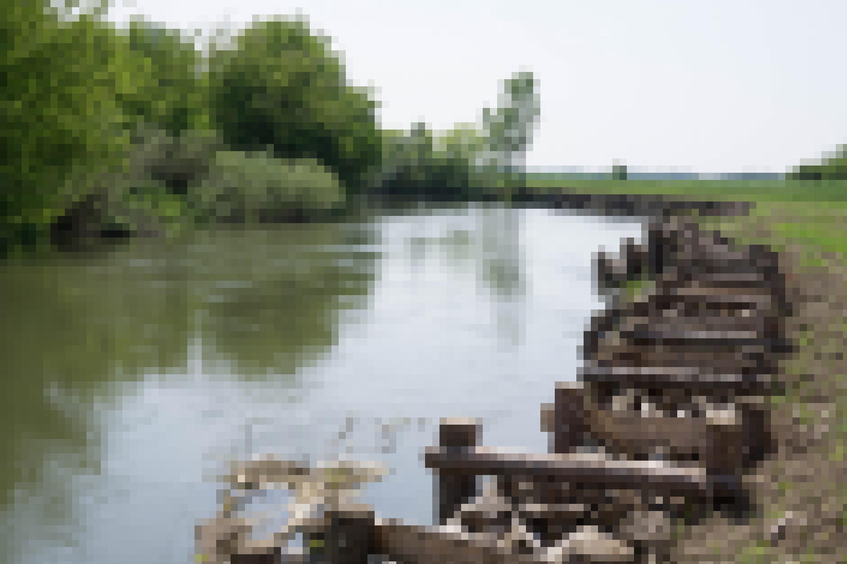 Fluss, rechts Ufer gesichert mit ein den Boden gerammten Baumstämmen.