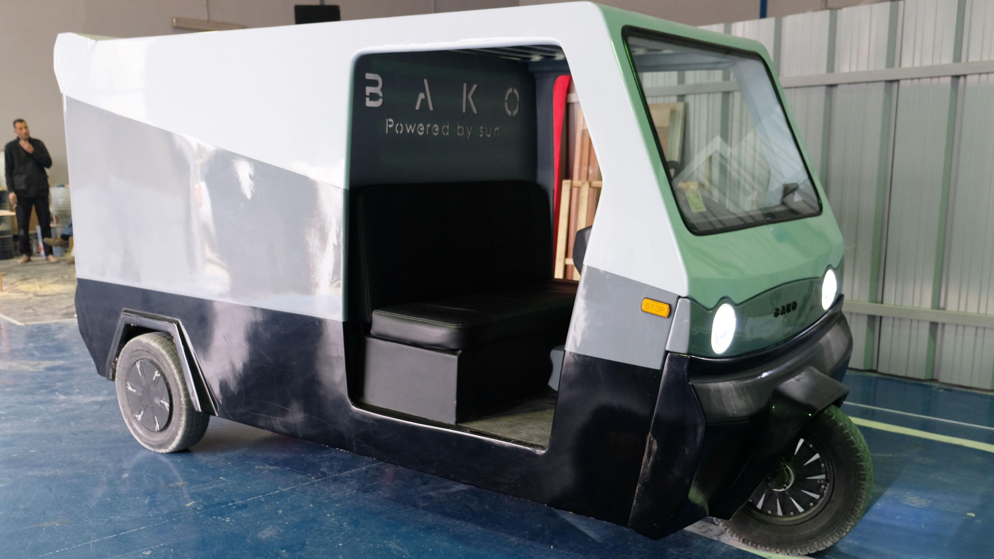 Ein kleines, kastiges Transportgefährt mit drei Rädern und einer Solarzelle auf dem Dach