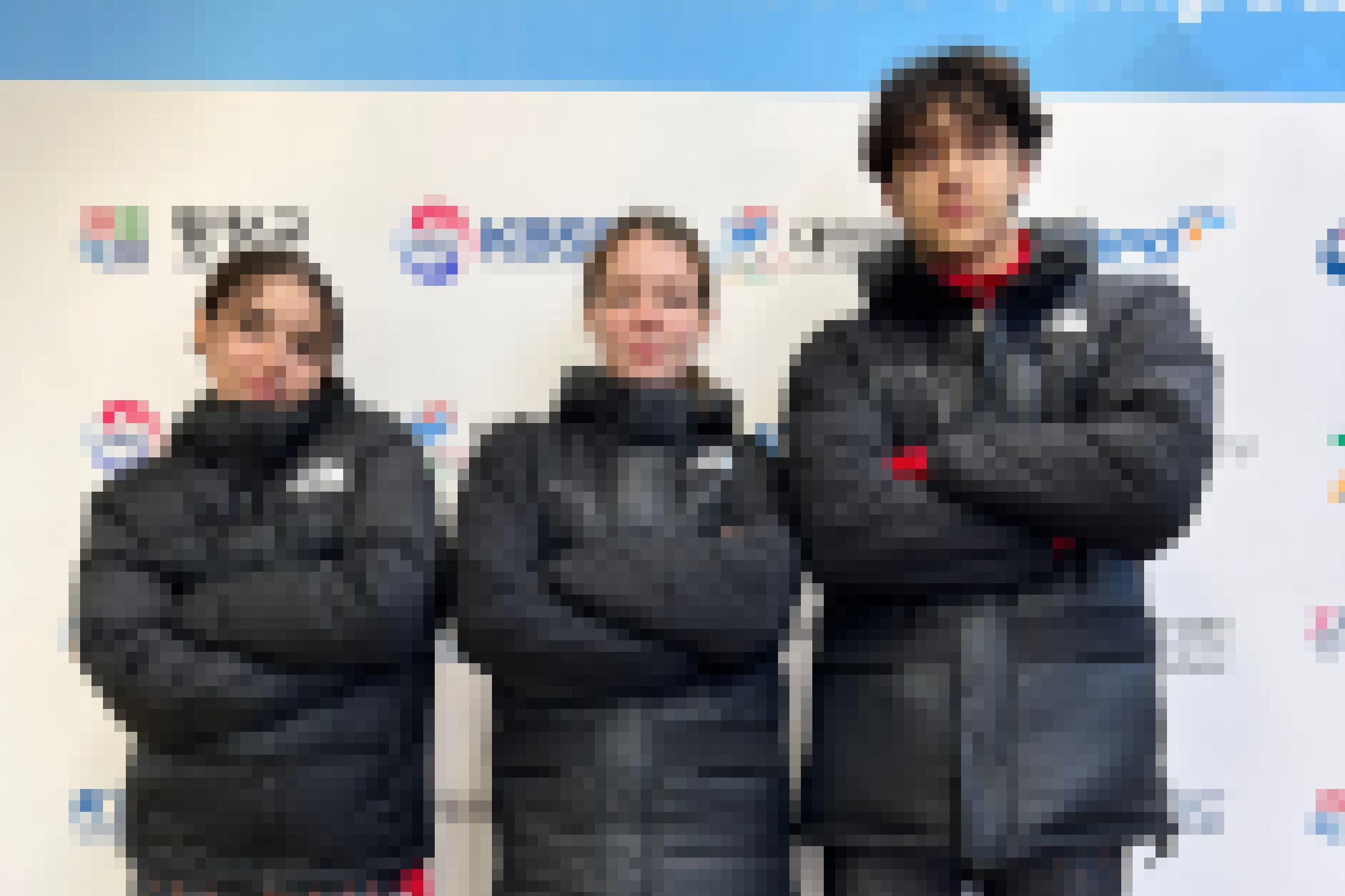 Drei Jugendliche stehen in Sportbekleidung nebeneinander und blicken in die Kamera