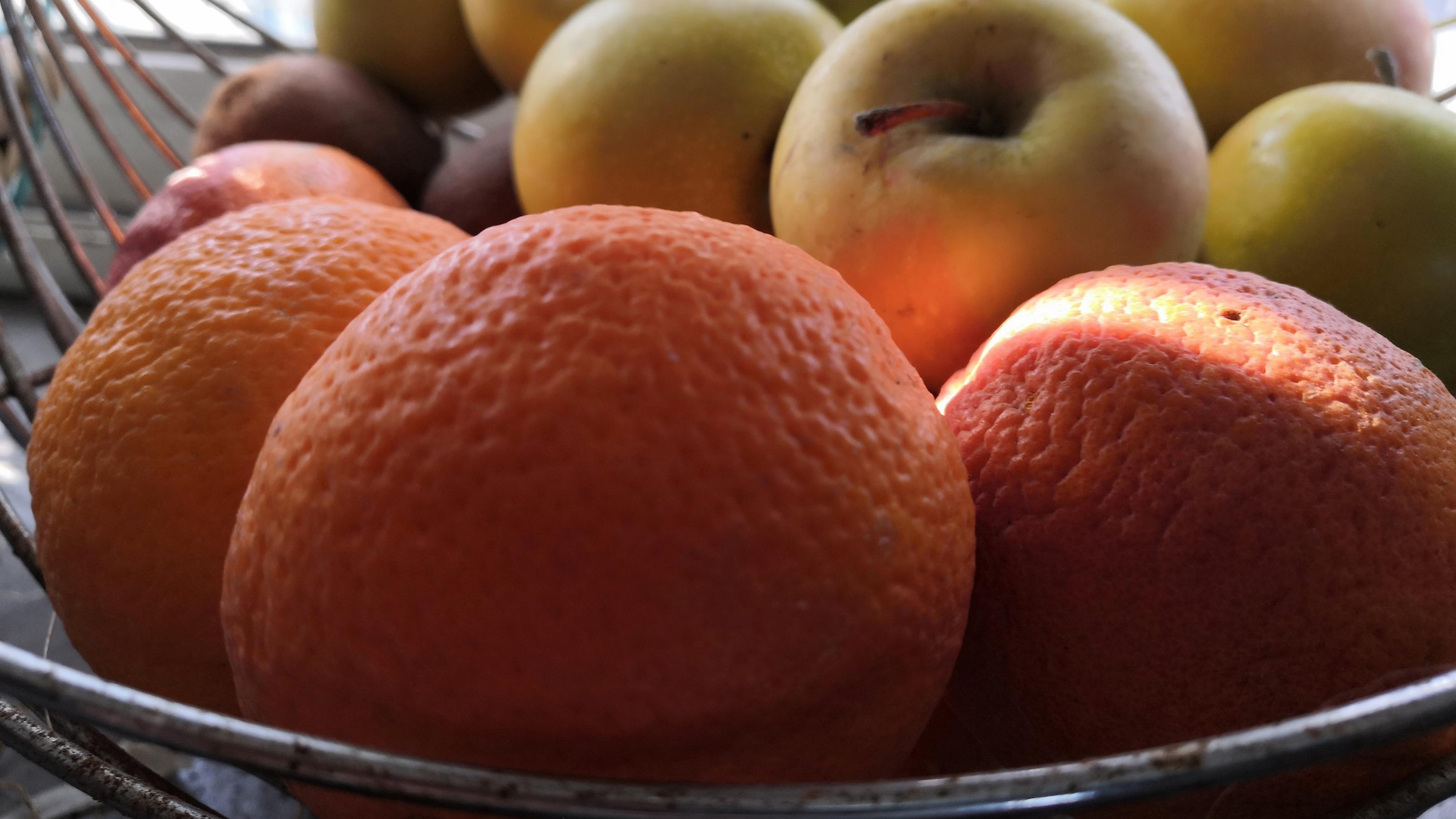 Ein Obstkorb mit Orangen, Kiwis und Äpfeln