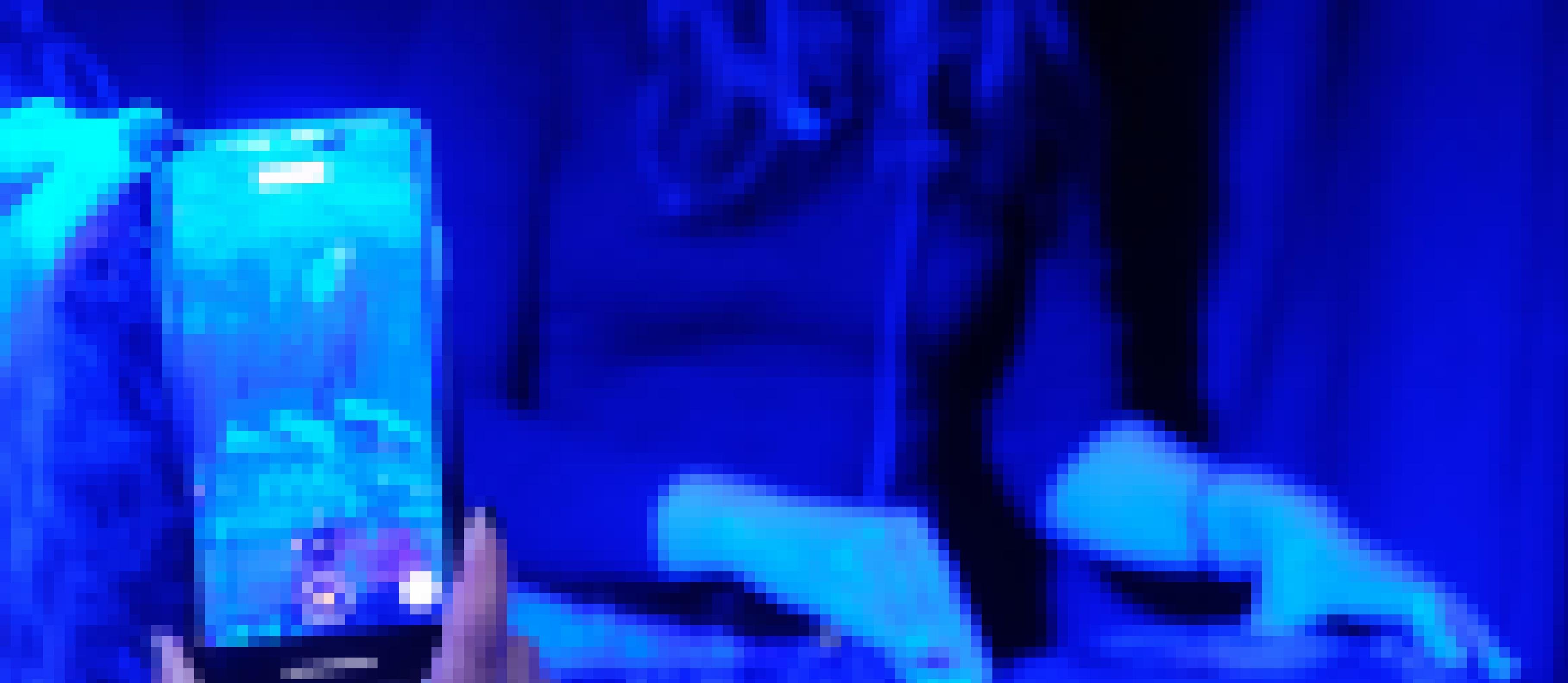 Eine Hand hält ein Handy und streamt den Mix einer Frau am Mischpult. Diese ist im Hintergrund verschwommen zu sehen.
