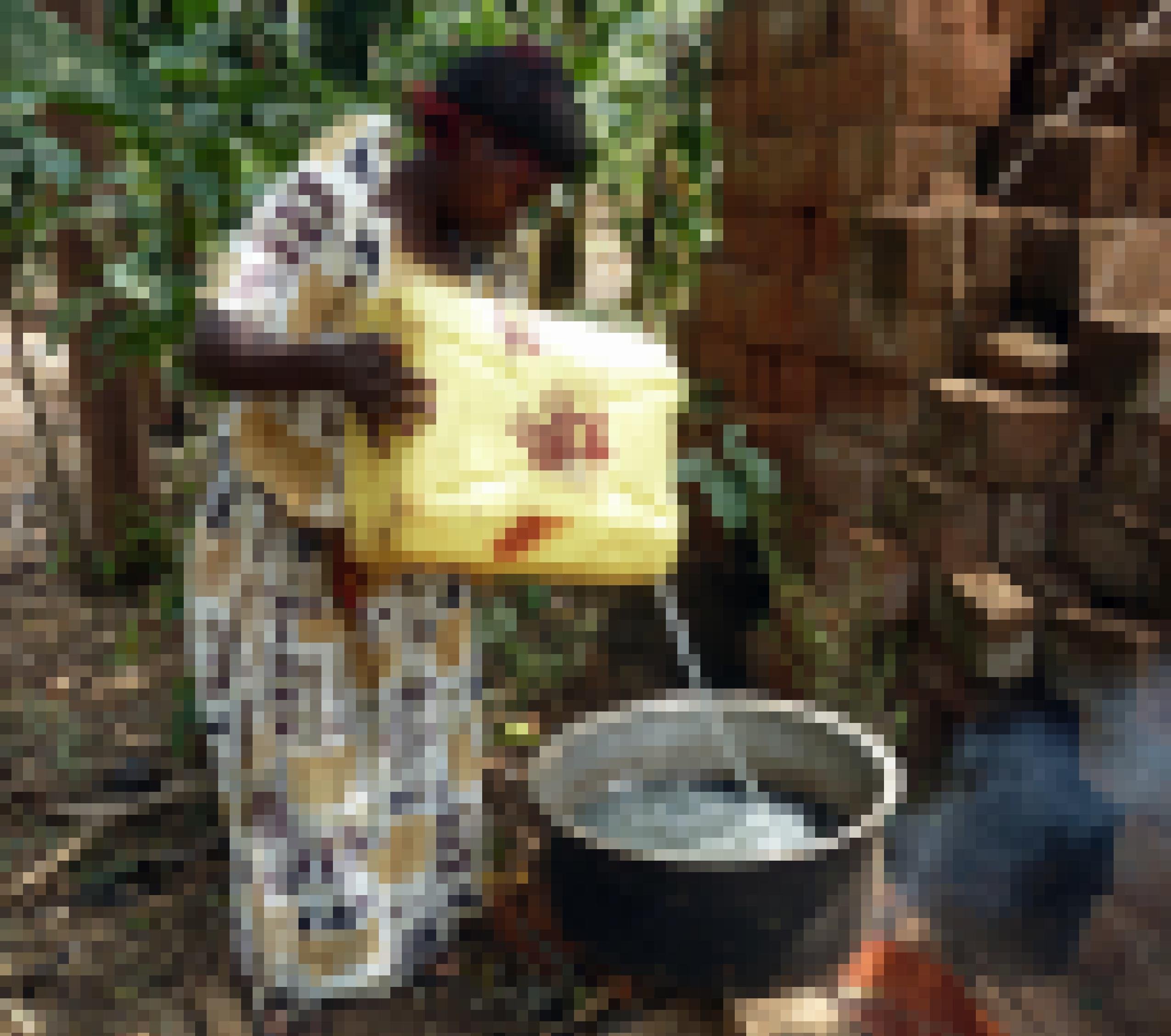 Die Frau des Kleinbbauern schüttet aus einem Plastikkanister Wasser in den großen Topf auf dem Feuer.