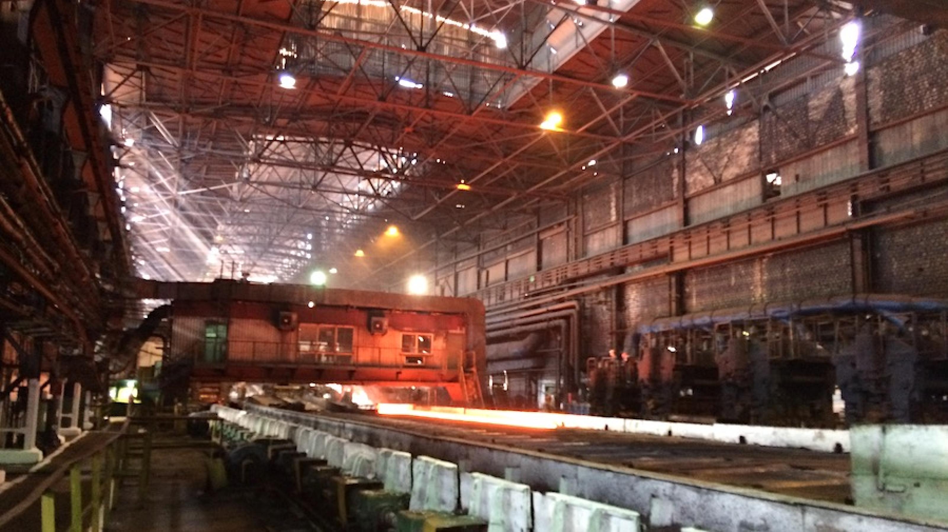 Blick in eine Produktionshalle von Asowstal, im Hintergrund wird glühender Stahl verarbeitet.