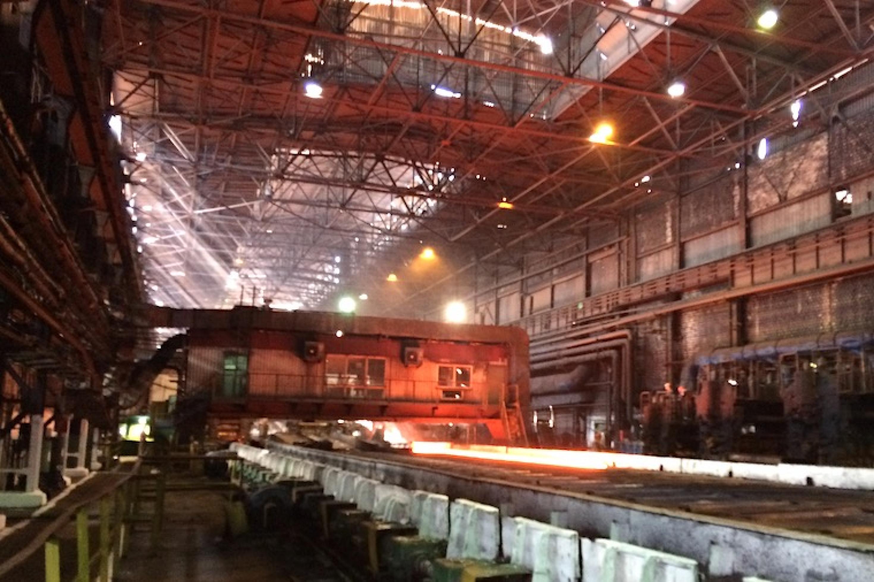 Blick in eine Produktionshalle von Asowstal, im Hintergrund wird glühender Stahl verarbeitet.