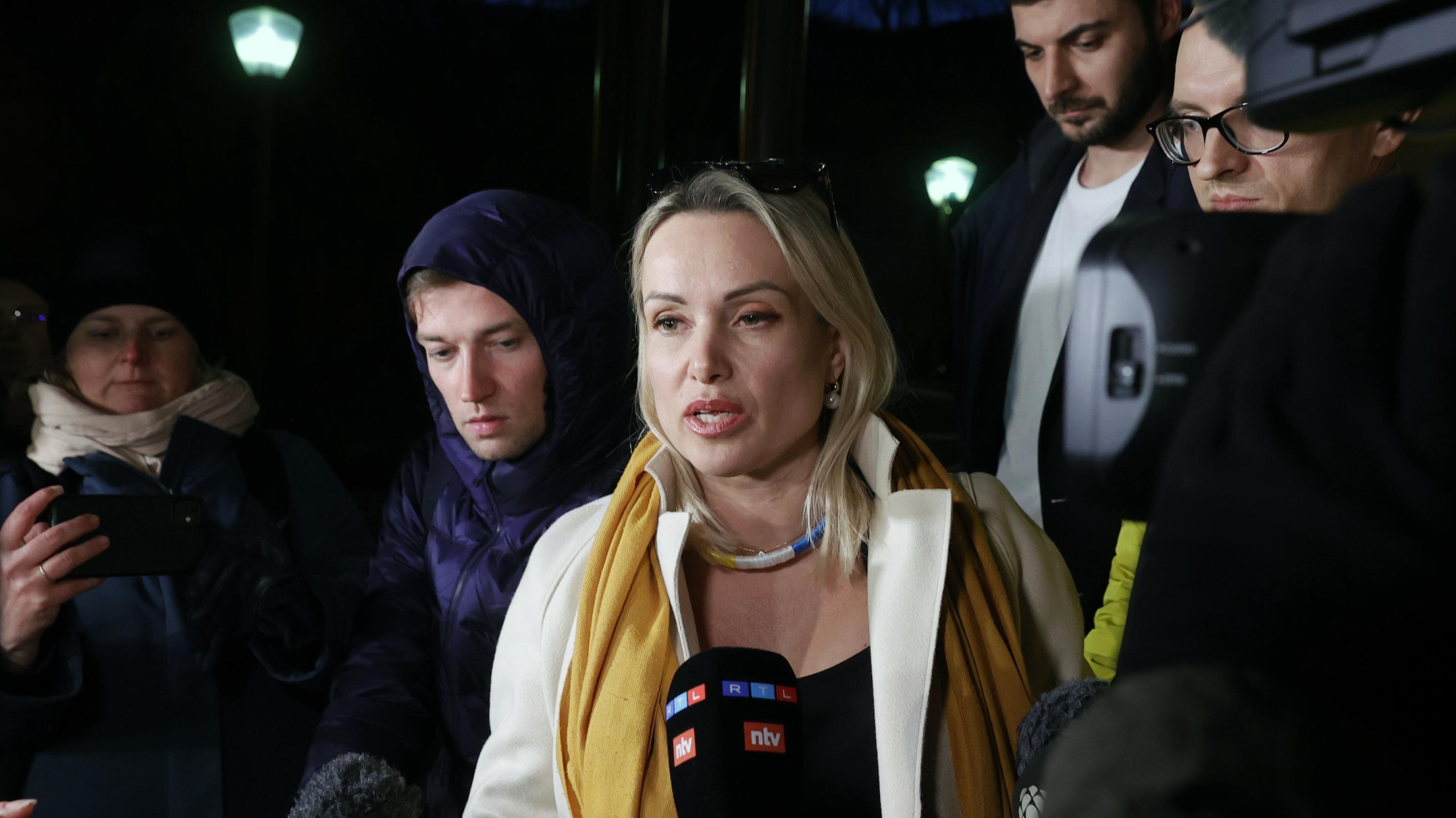 Eine Frau (Marina Owsjannikowa) spricht in die Mikrofone von Journalisten, die sie umringen.