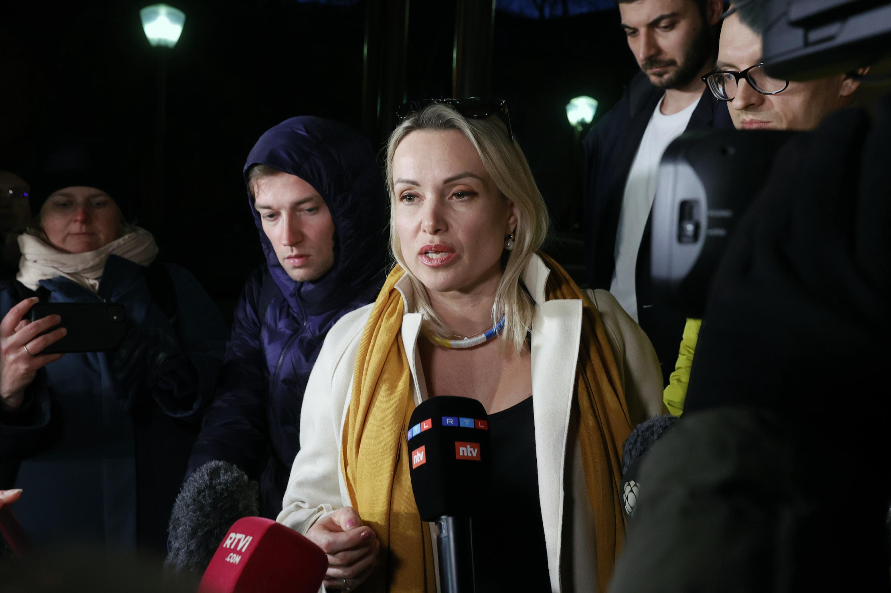 Eine Frau (Marina Owsjannikowa) spricht in die Mikrofone von Journalisten, die sie umringen.