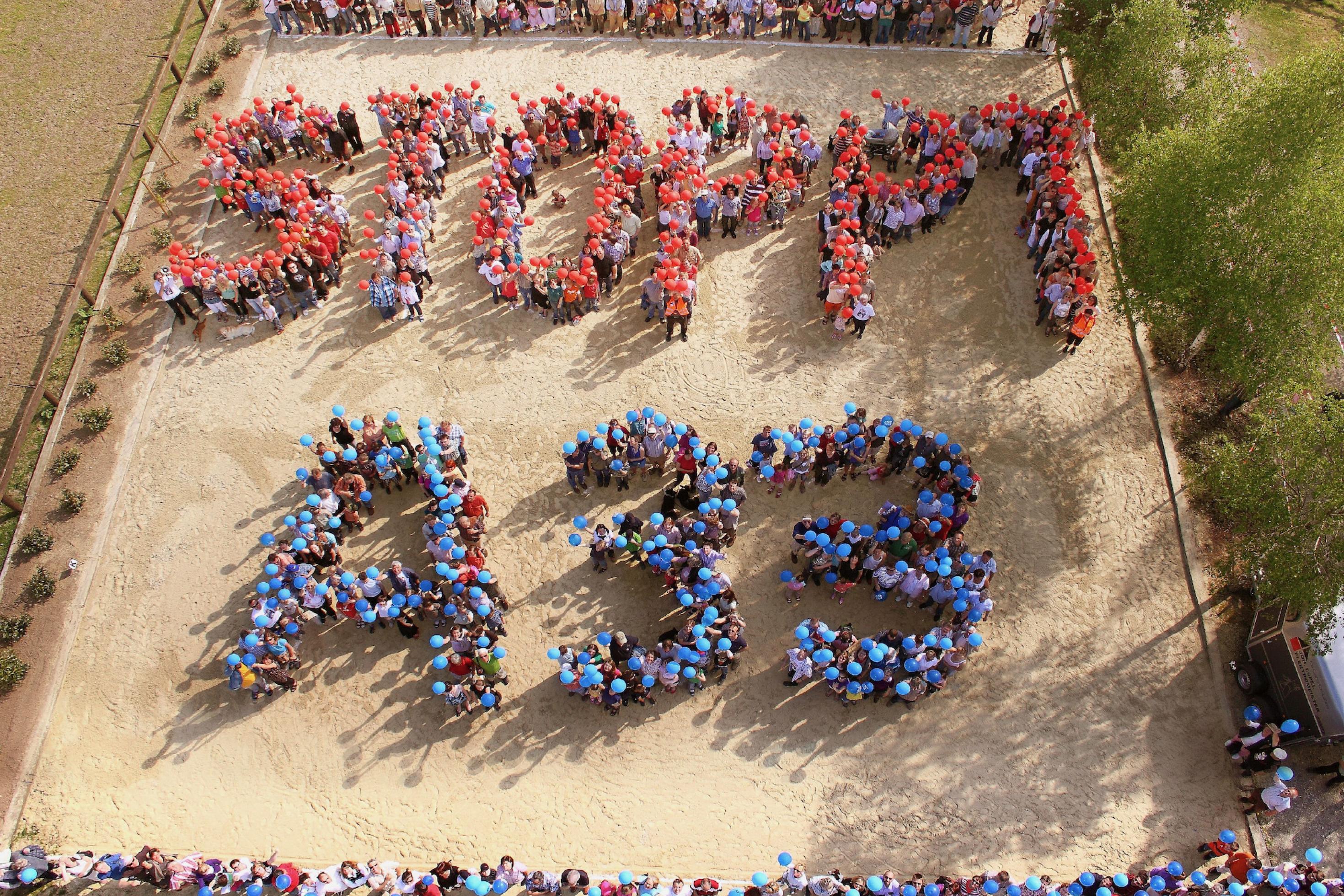 Aktivistinnen mit roten und blauen Luftballons formen die Buchstaben: Stoppt A 33.