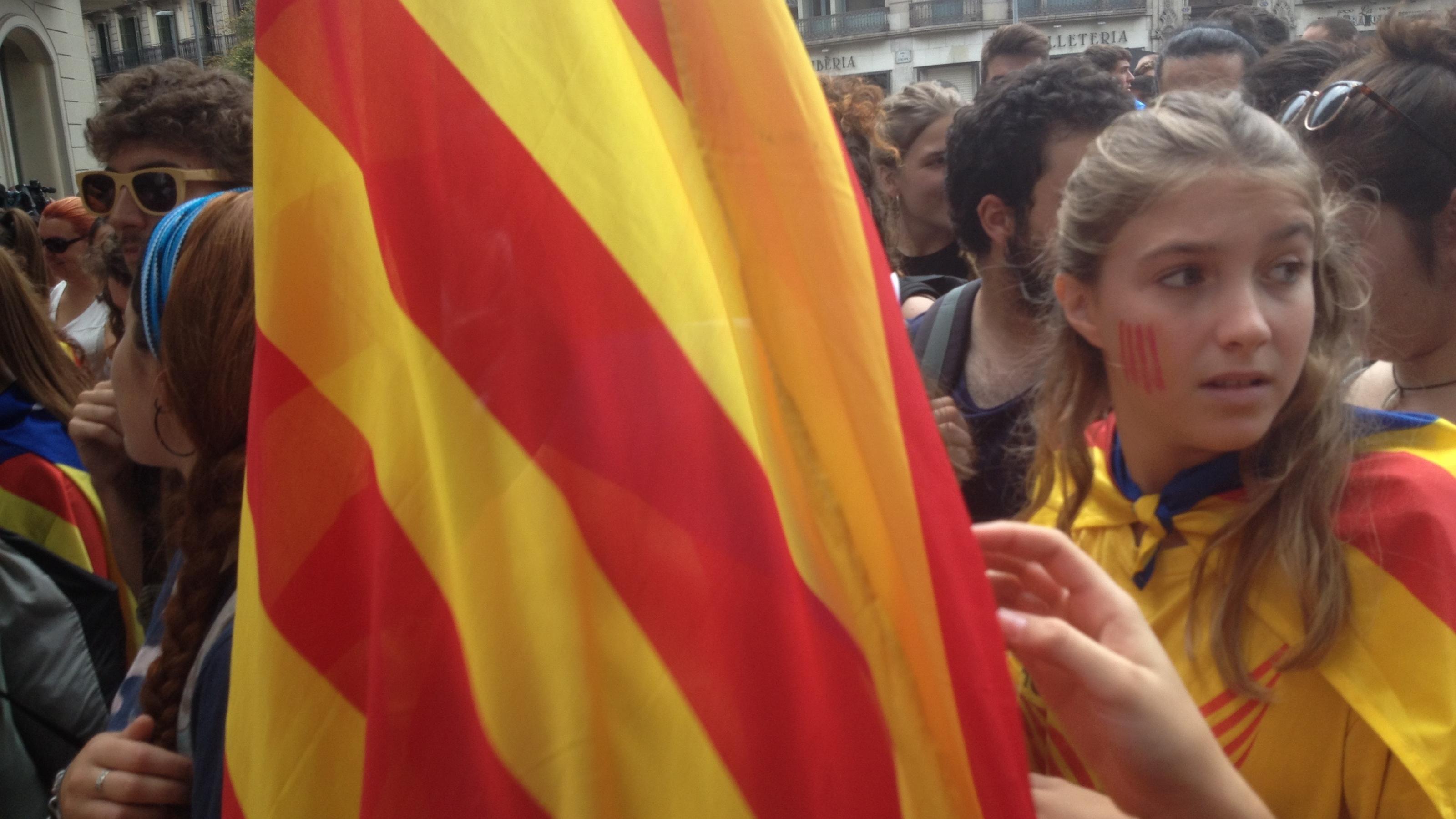 Unabhängigkeitsdemonstration am 3. Oktober 2017 auf der Rambla Catalunya in Barcelona: Ein Mädchen mit gelb-roter Schminke auf der Wange hält die katalanische Nationalflagge.
