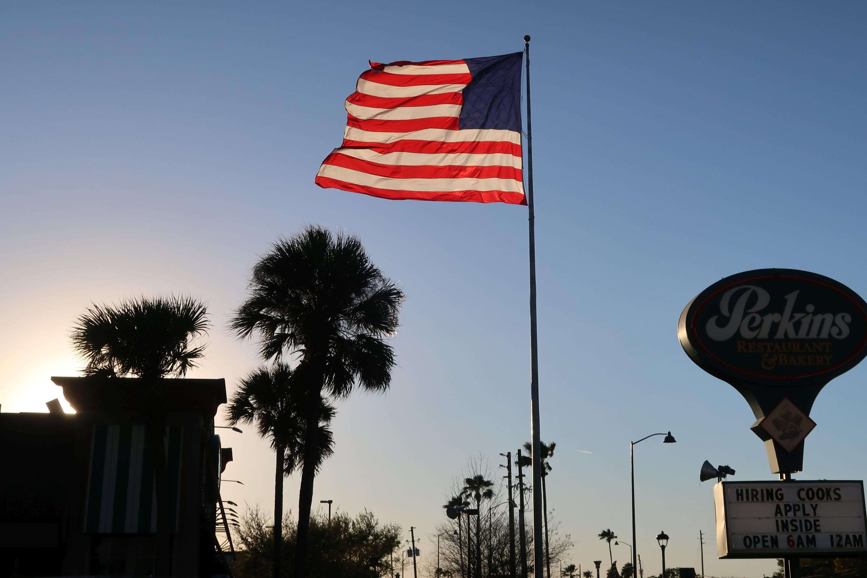 Eine US-amerikanische Fahne weht im Sonnenuntergang