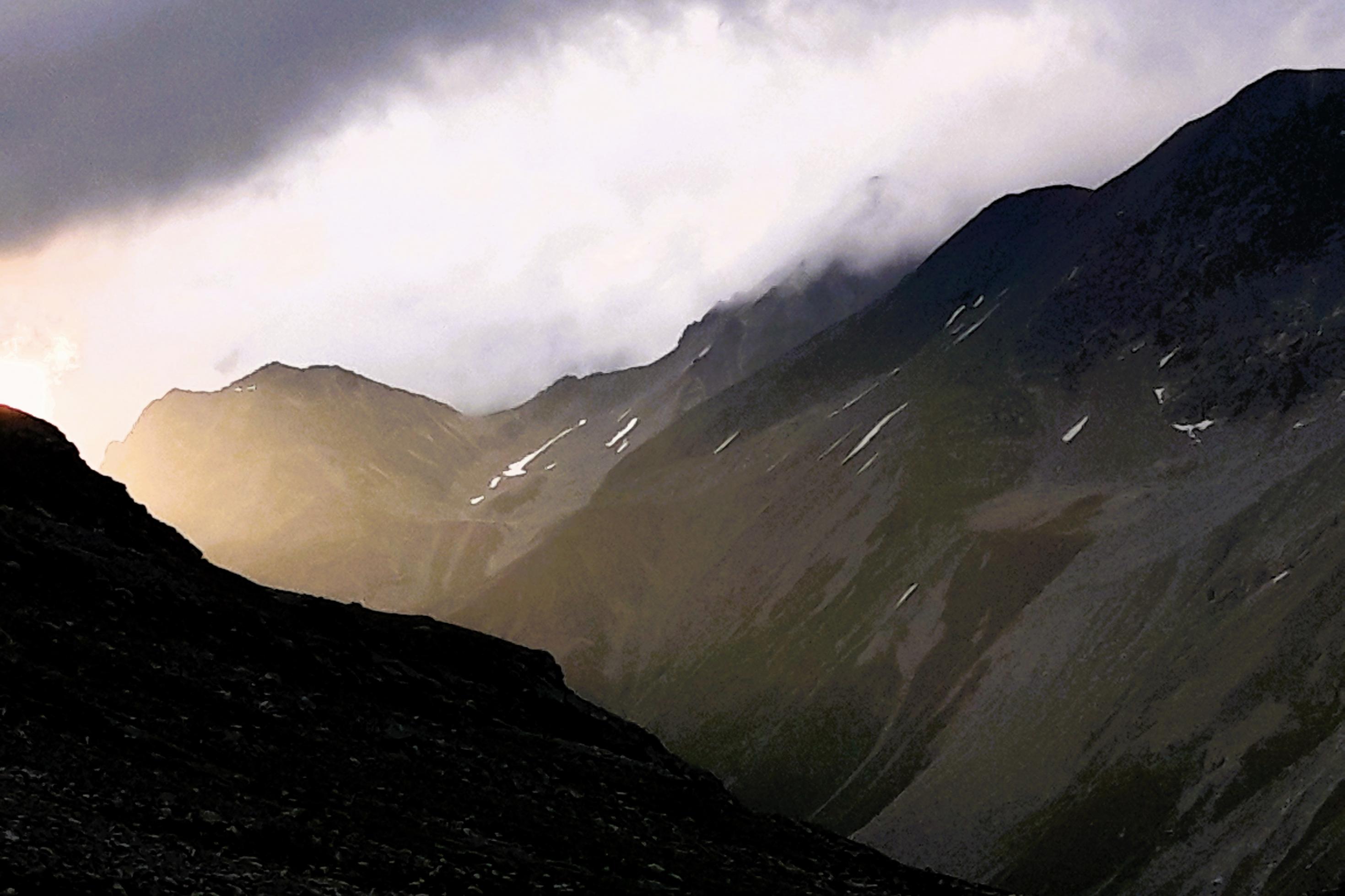 Dramatische Wolkenszenerie über einem markanten Taleinschnitt.