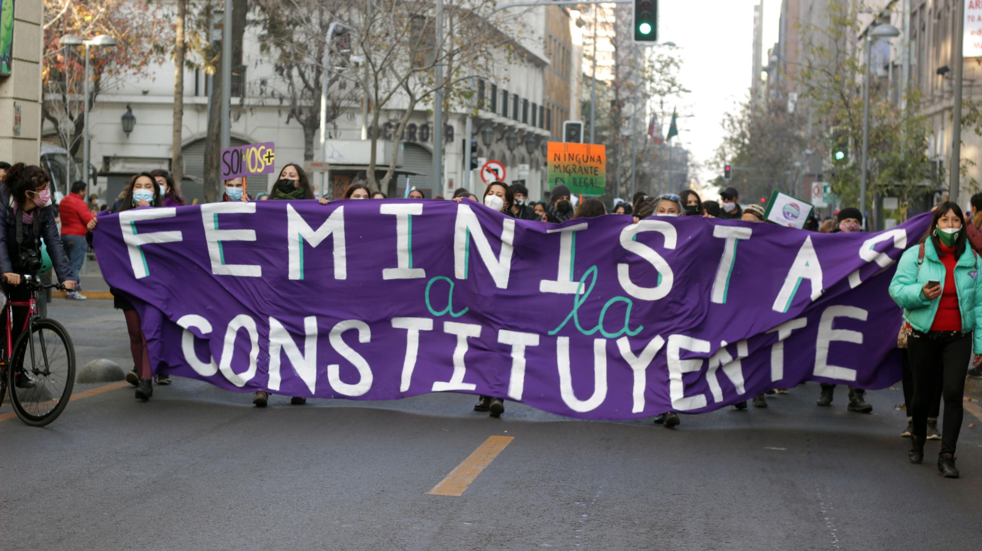Eine Gruppe von Demonstrantinnen hält ein großes Banner fest mit der Aufschrift: „Feministinnen in den Verfassungskonvent“