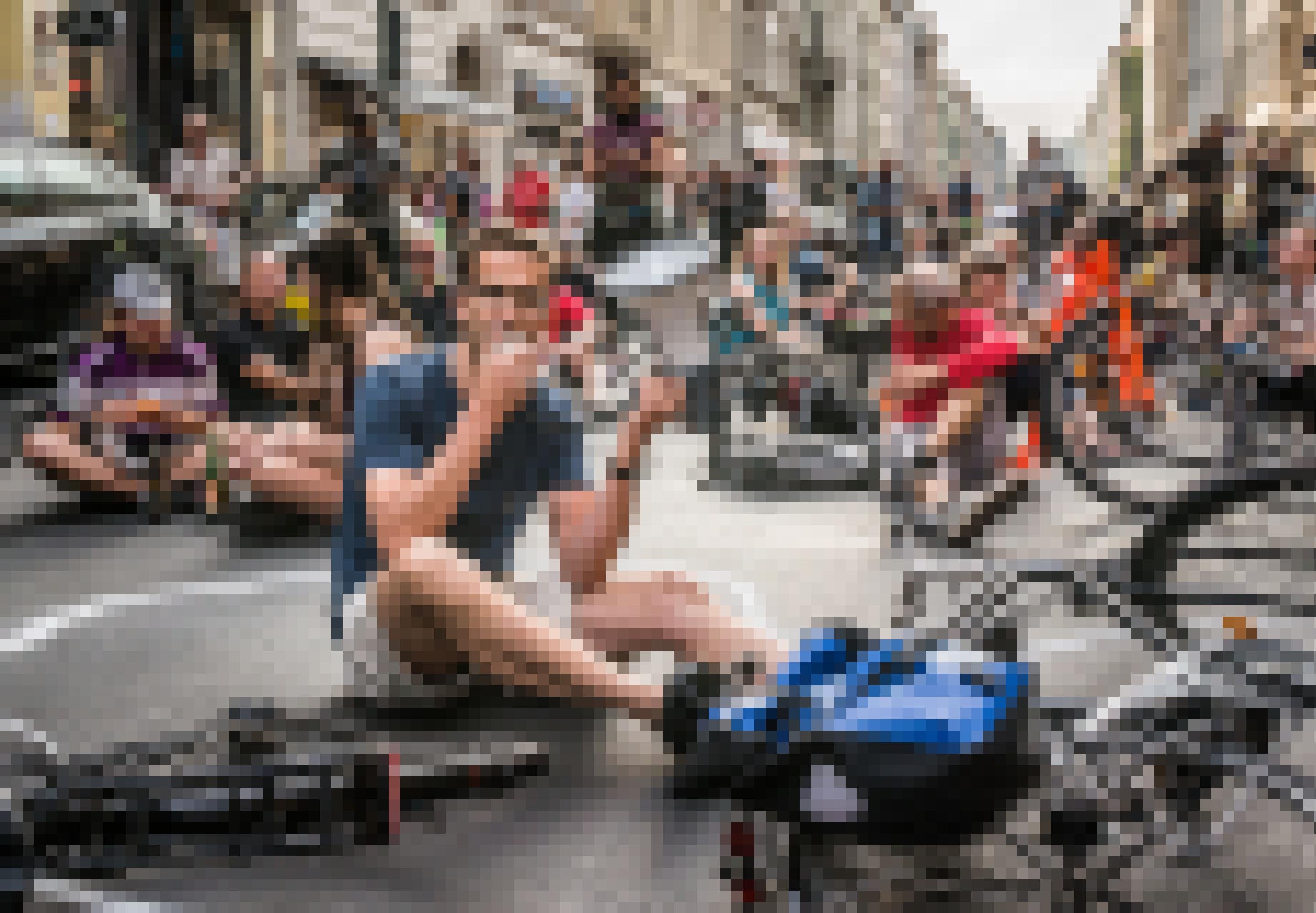 Menschen sitzen auf der Straße, einer von ihnen hat ein Megafon in der Hand