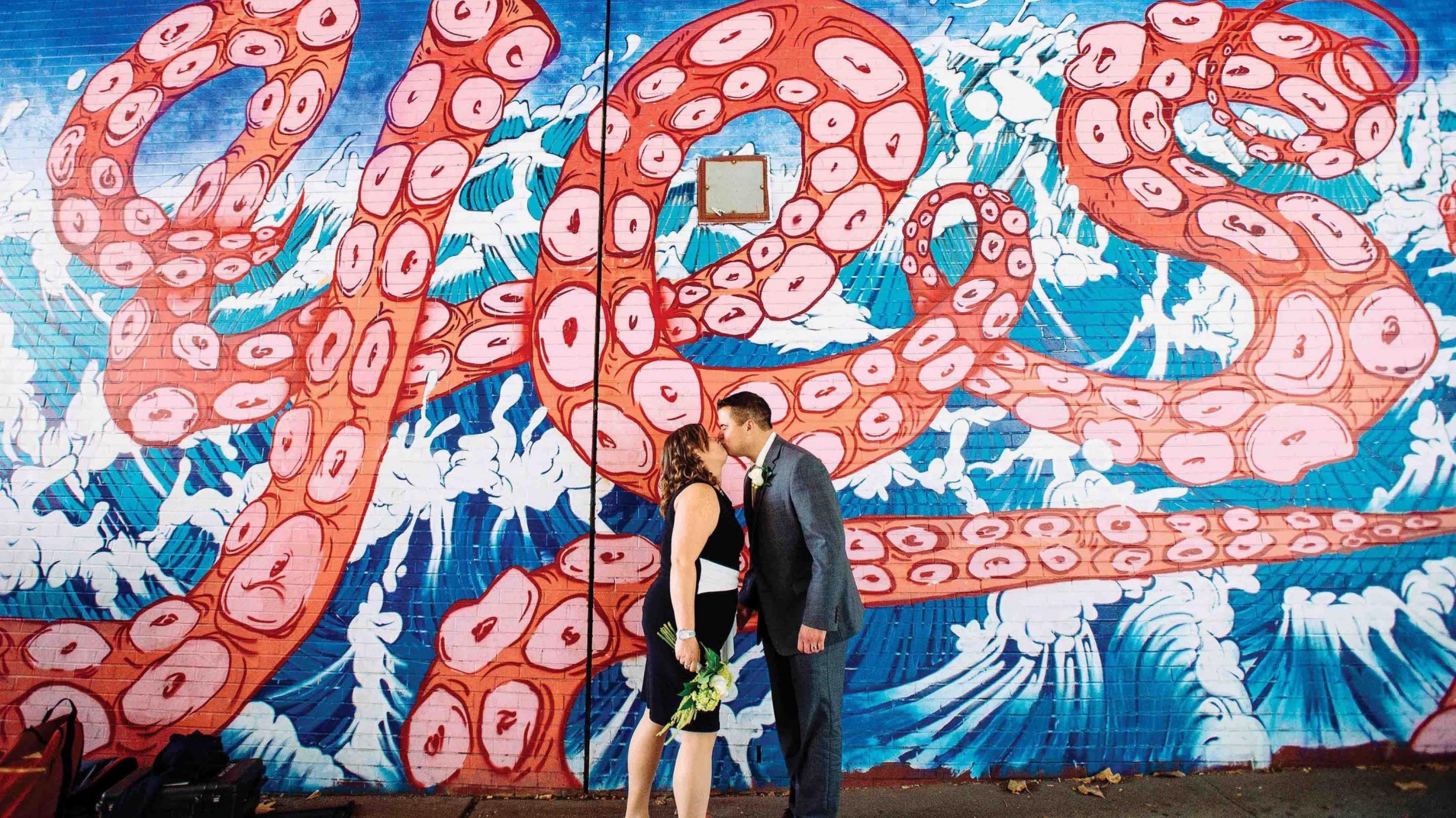 Ein Mann und eine Frau küssen sich vor einem Yes-Schriftzug