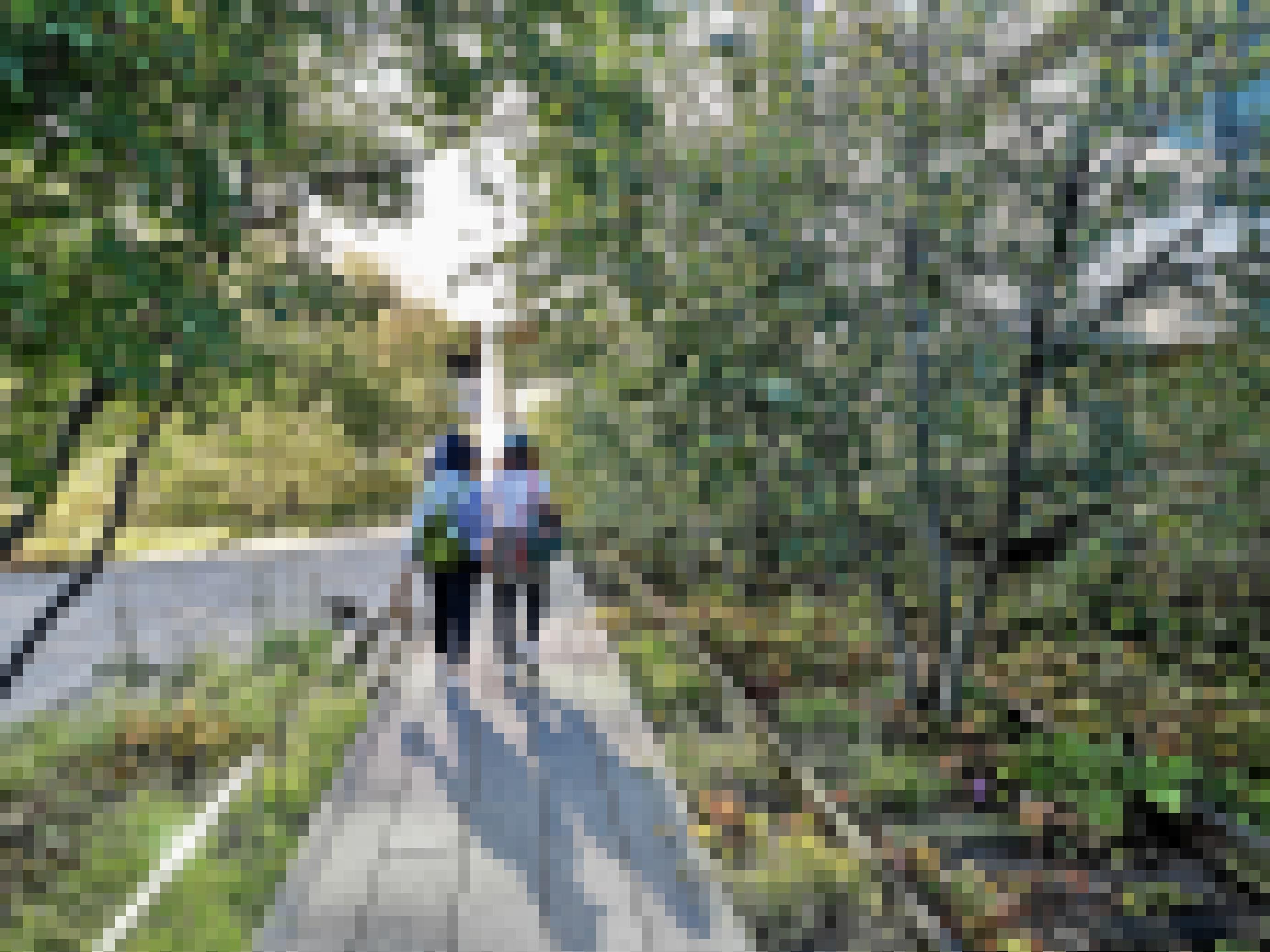 Zwei Frauen gehen auf der Hochbahntrasse im Schatten der Bäume