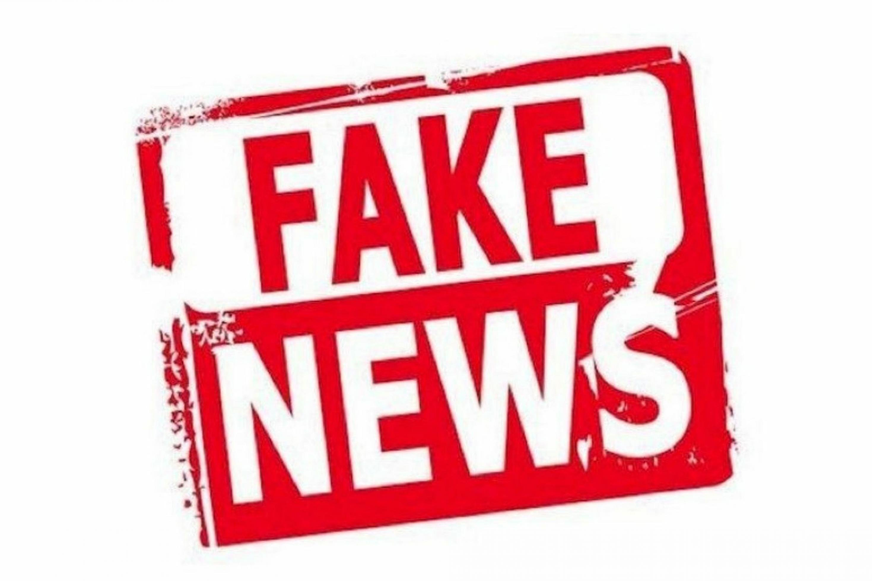 Ein alarmierender stempelartiger Schriftzug (rot auf weißem Grund) mit „Fake News“ in Großbuchstaben.