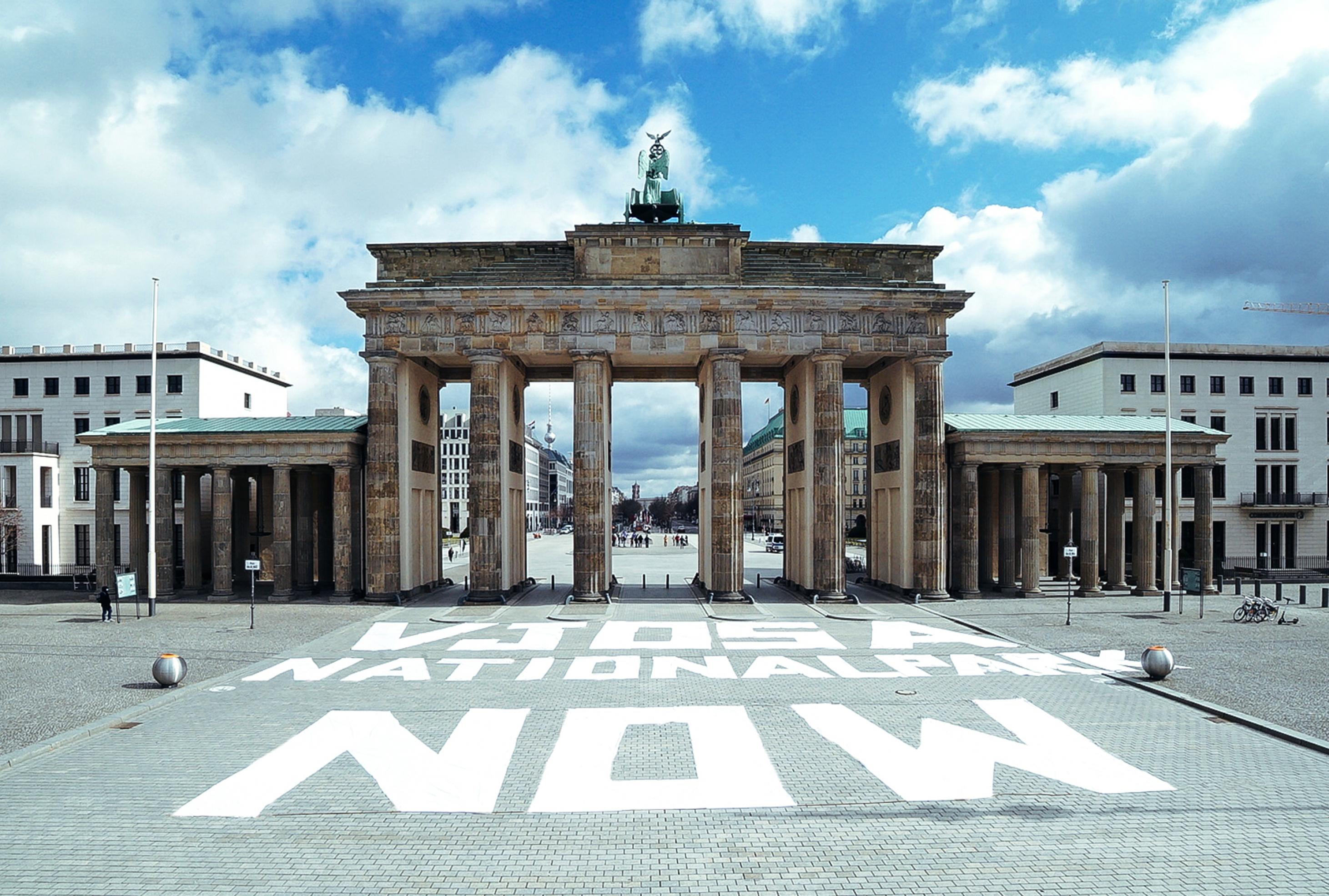 Brandenburger Tor in Berlin, davor auf dem Platz große weiße Buchstaben: Vjosa national park now