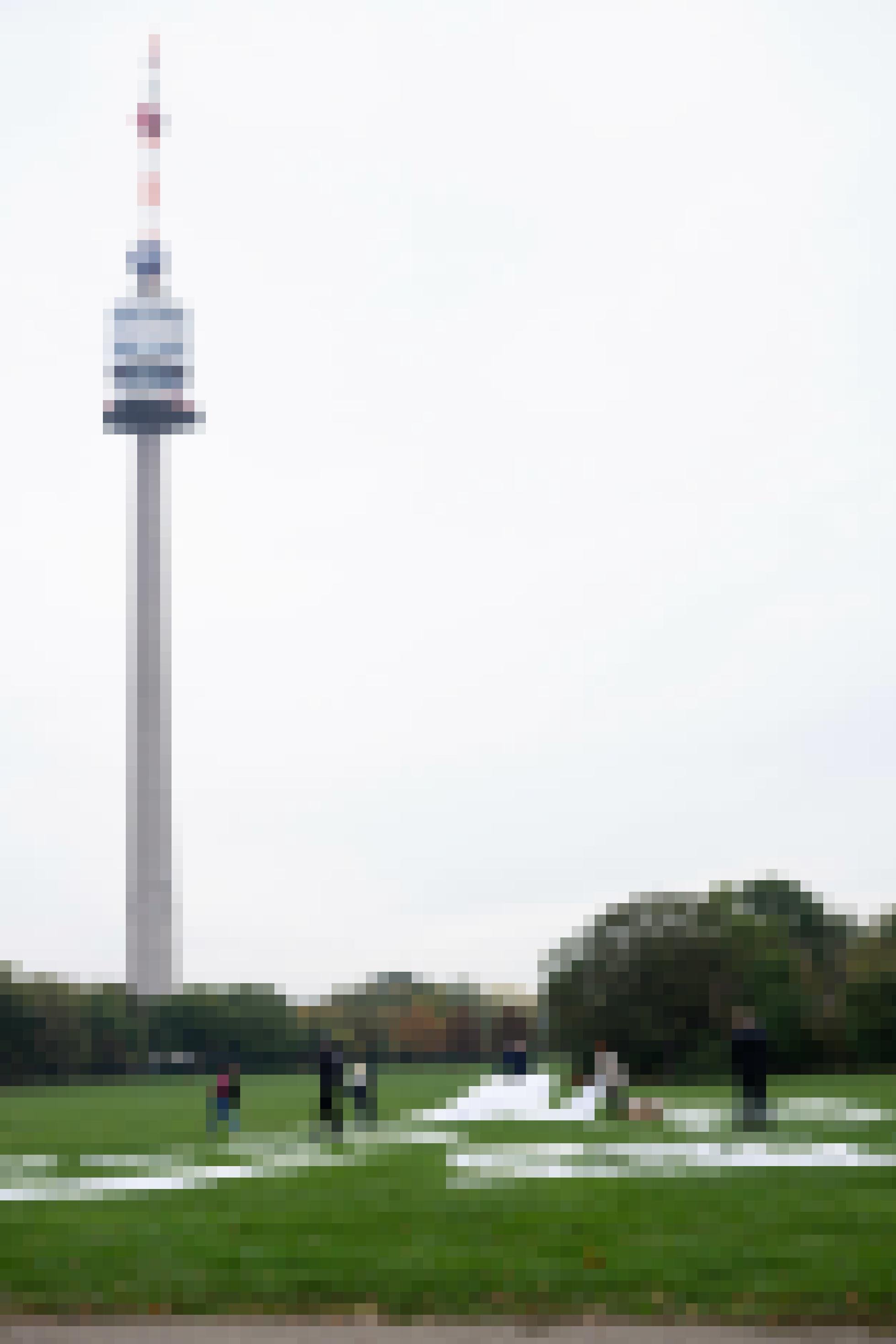 Hoher Turm im Hintergrund, vorne Wiese mit weißen Buchstaben.