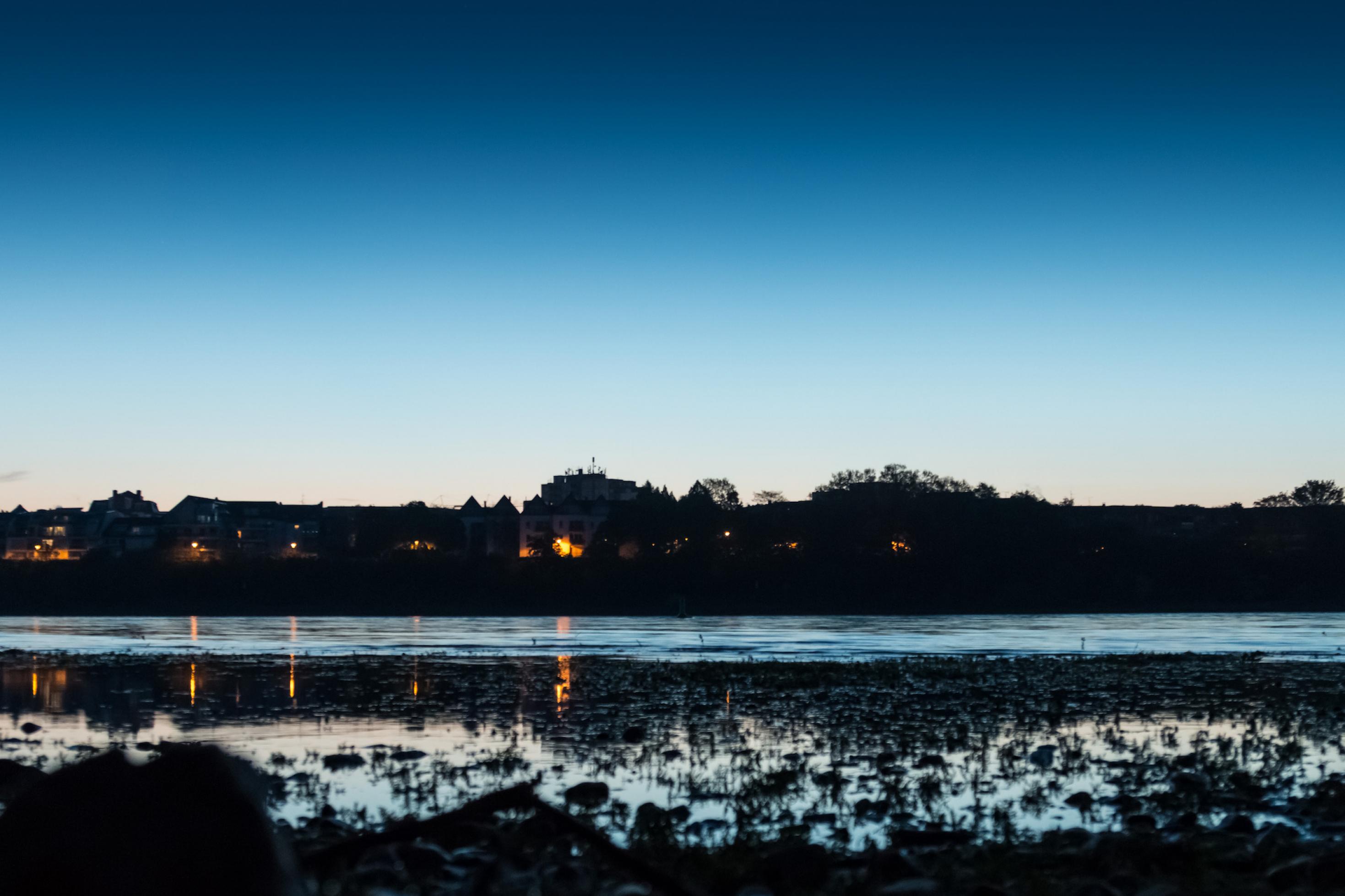 Aufnahme des Rheins bei Dämmerung vom Ufer aus.