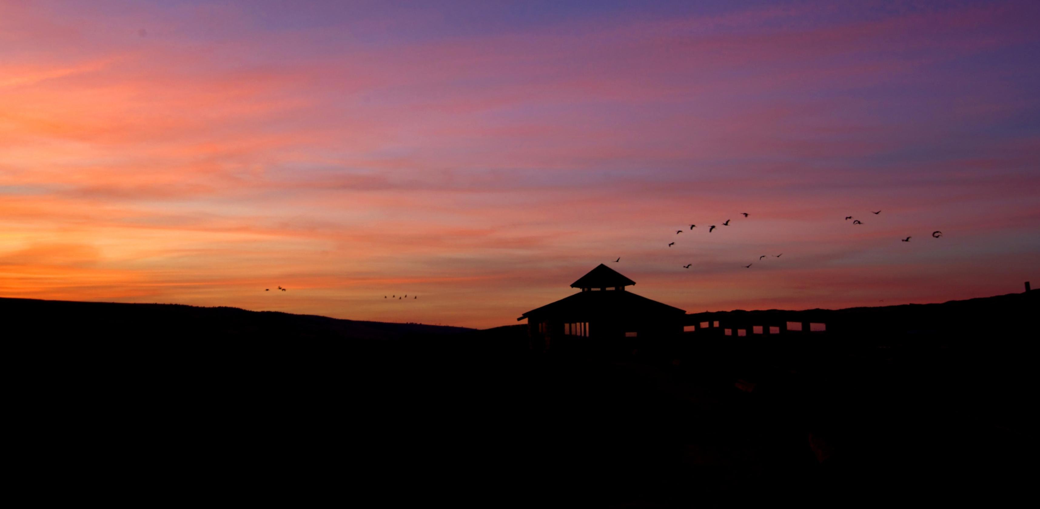 Silhouette einer Beobachtungshüte bei Sonnenaufgang