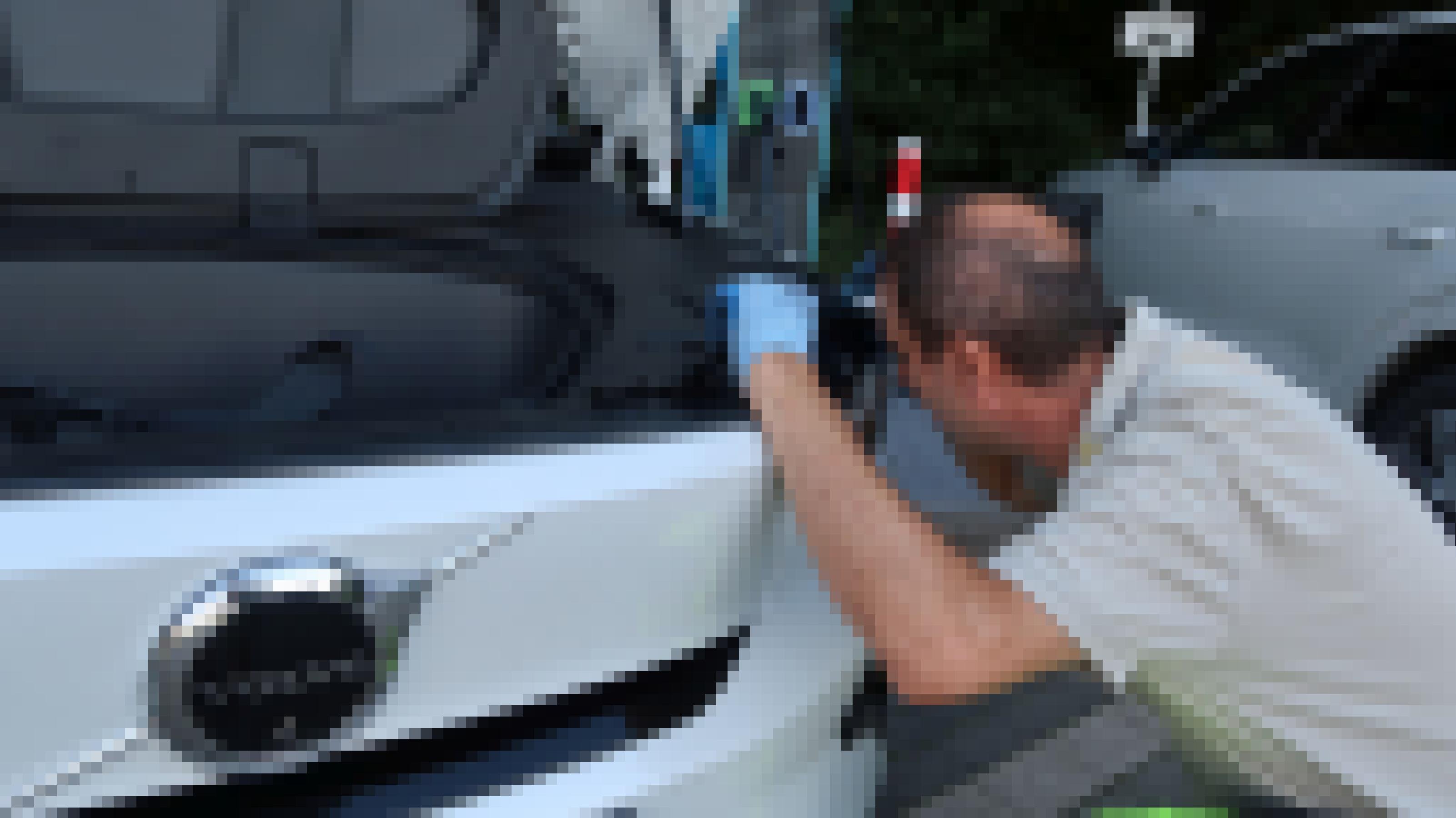 Pannenhelfer kniet vor Volvo C40 und schaut in Motorraum