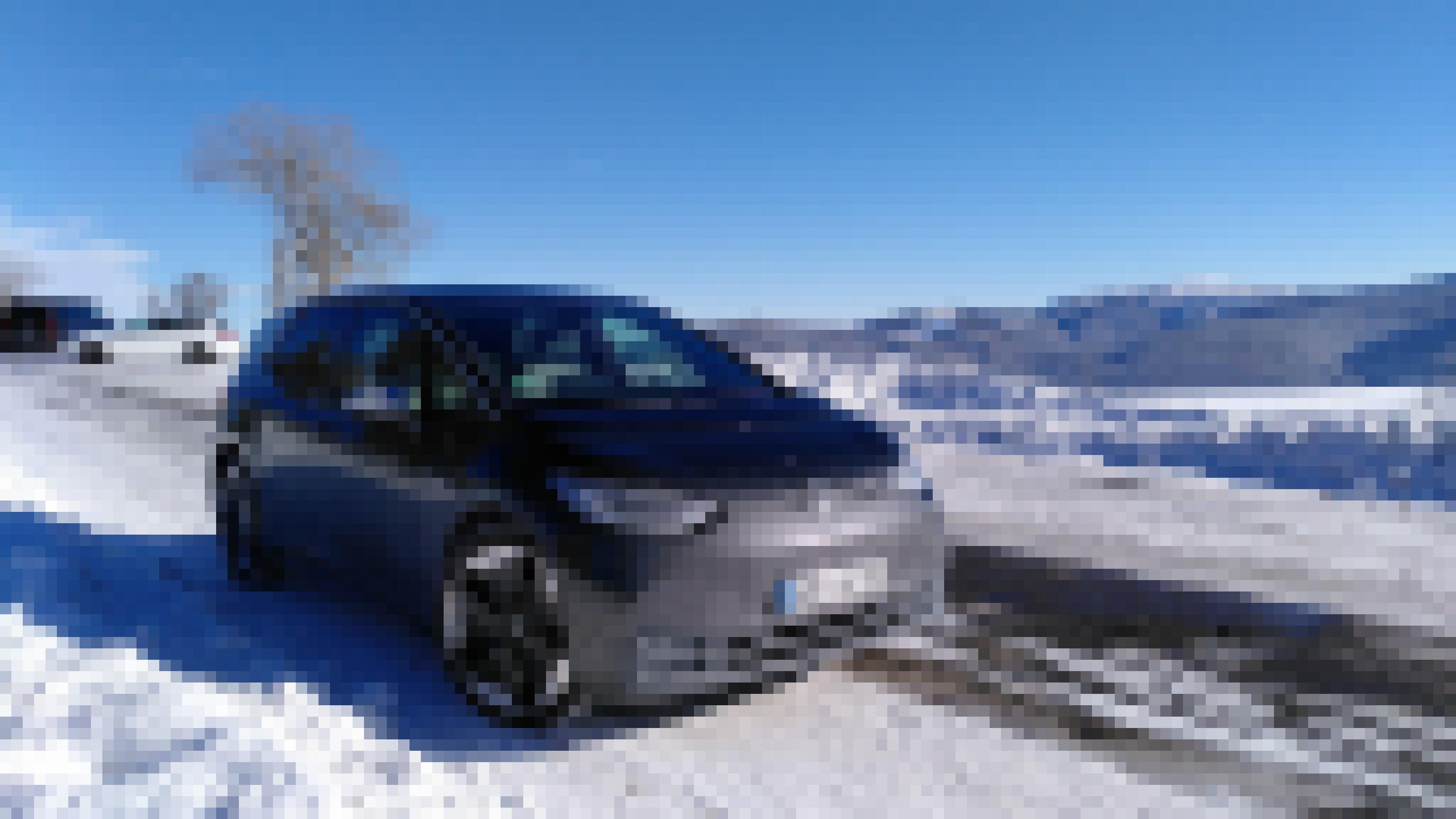 Ein Elektroauto parkt auf einem zugeschneiten Parkplatz. Im Hintergrund sieht man verschneite Berge.