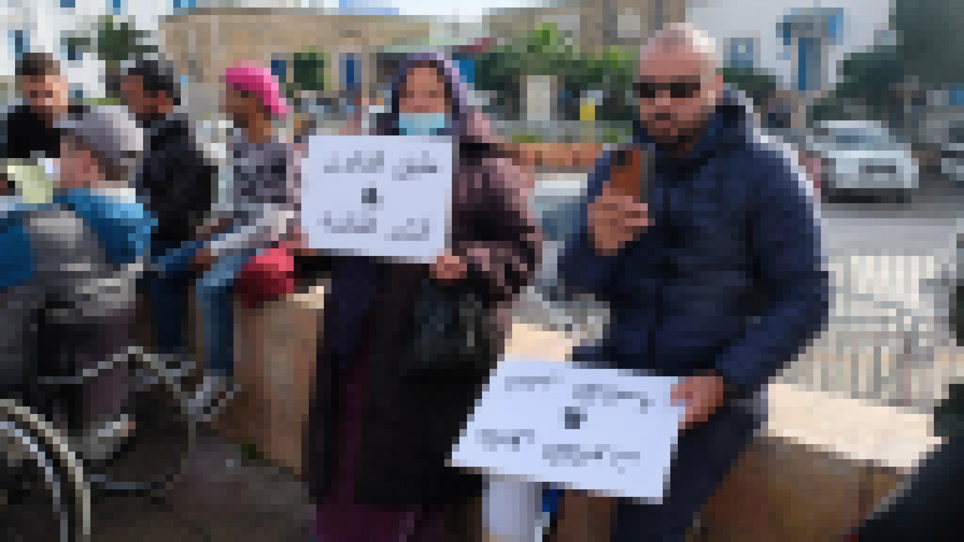 Ein junger Mann und eine alte Dame sitzen mit Protestplakaten vor dem Regierungssitz in Tunis, Tunesien.