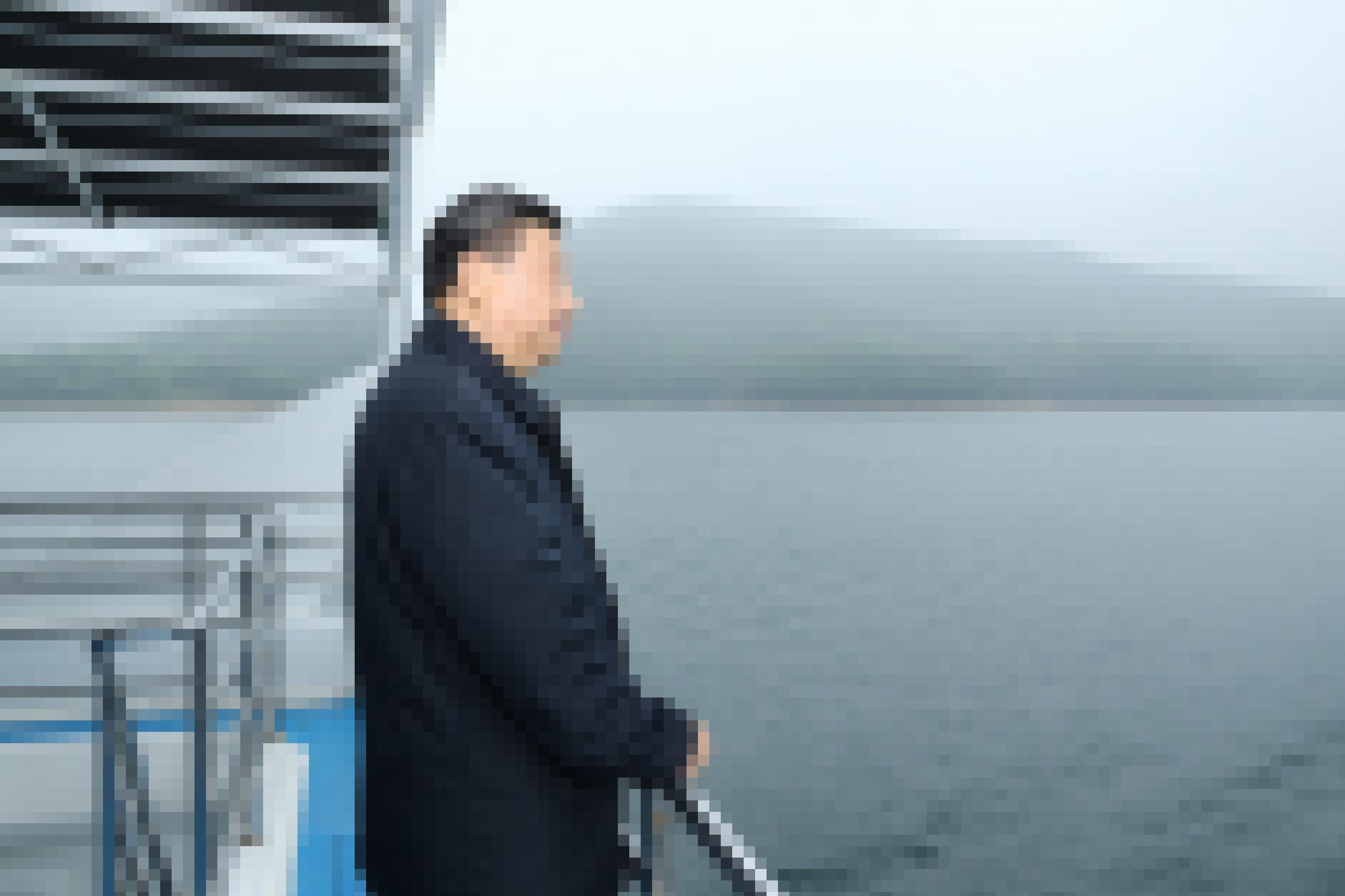 Xi Jinping steht an der Reling eines Bootes und schaut auf einen See.