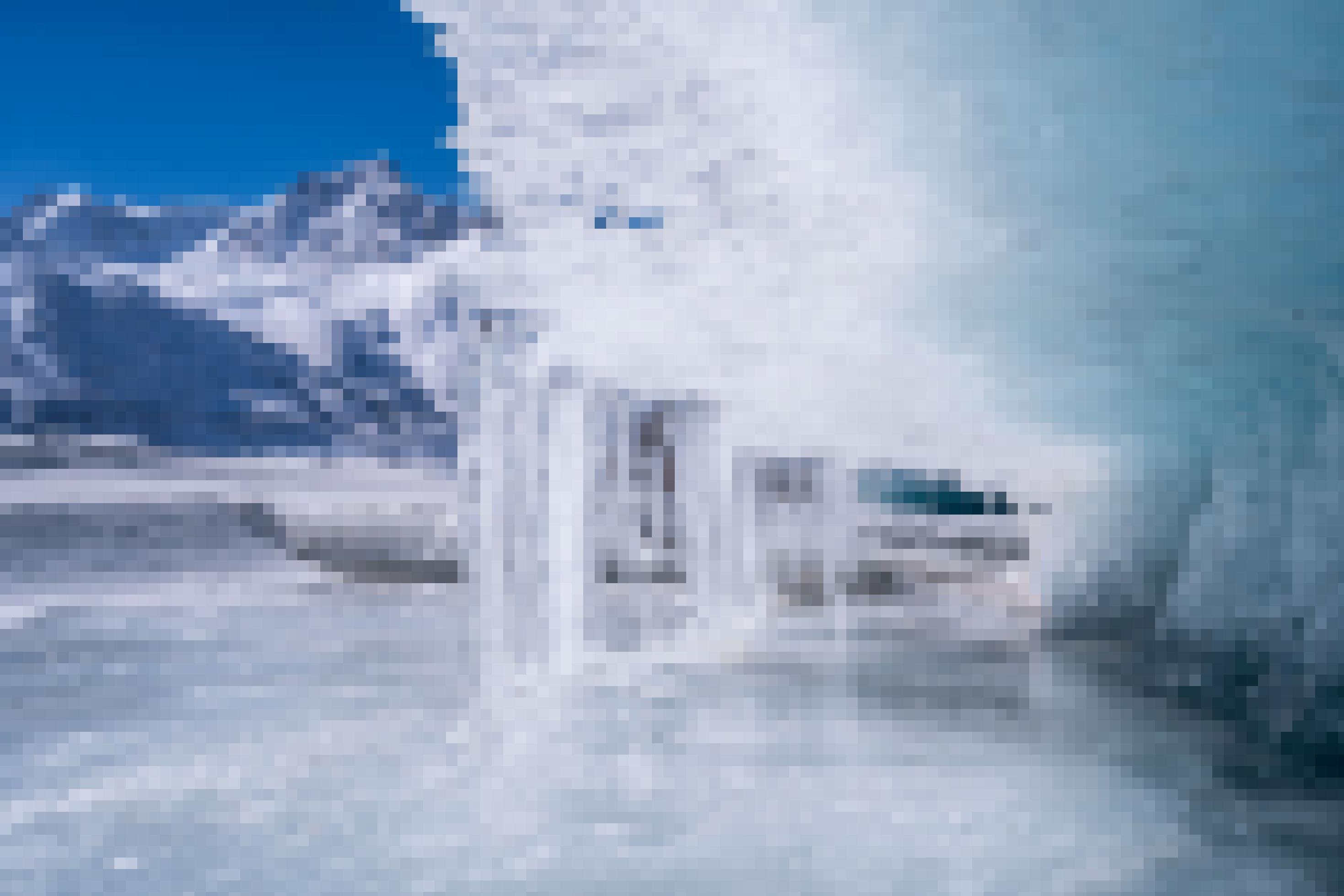 Eislandschaft im HImalaya, gefrorenes Schmelzwasser eines Gletschers formt sich zu einer Welle, im Hintergrund Berge.