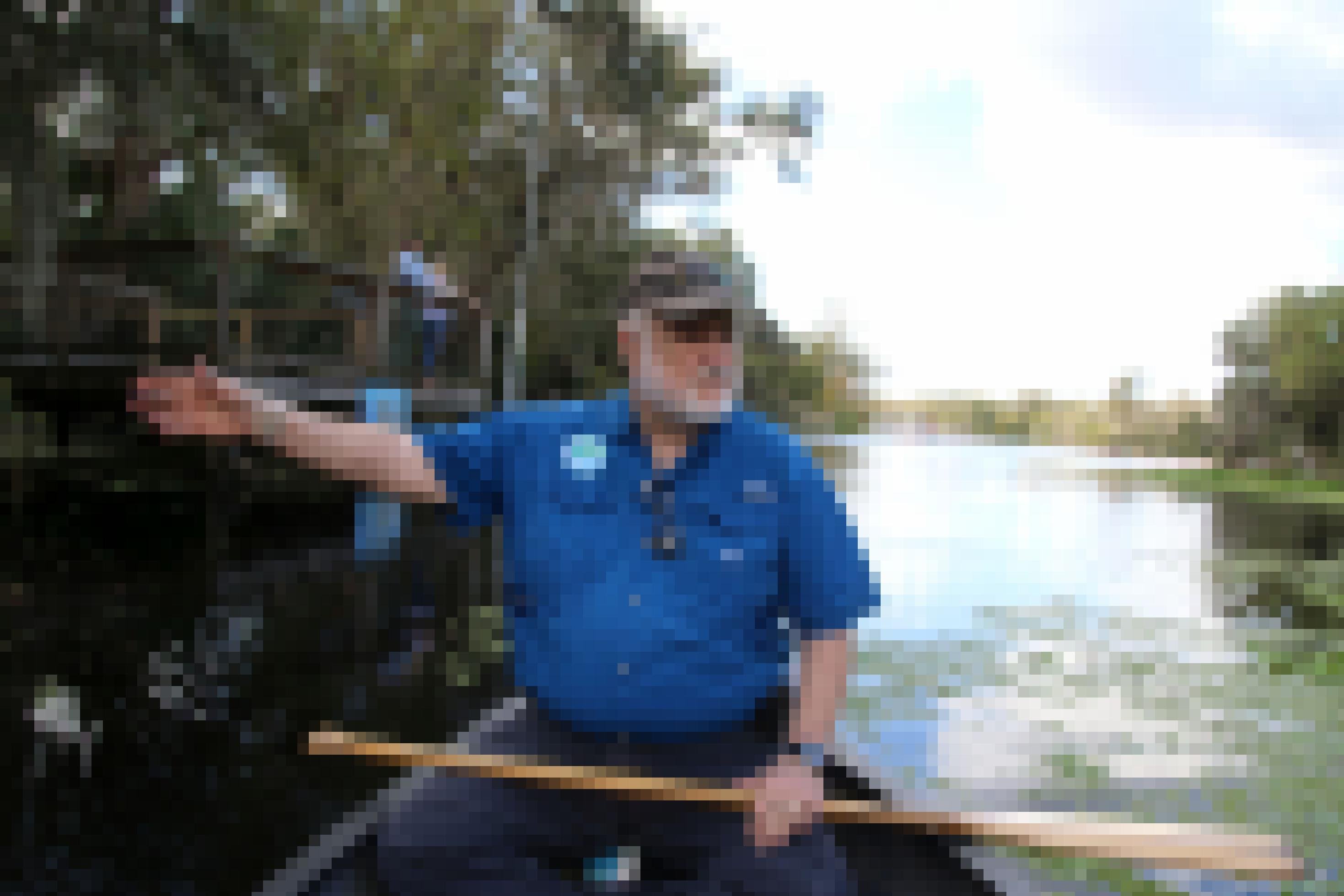Älterer Herr paddelt im Floß durch Mangroven