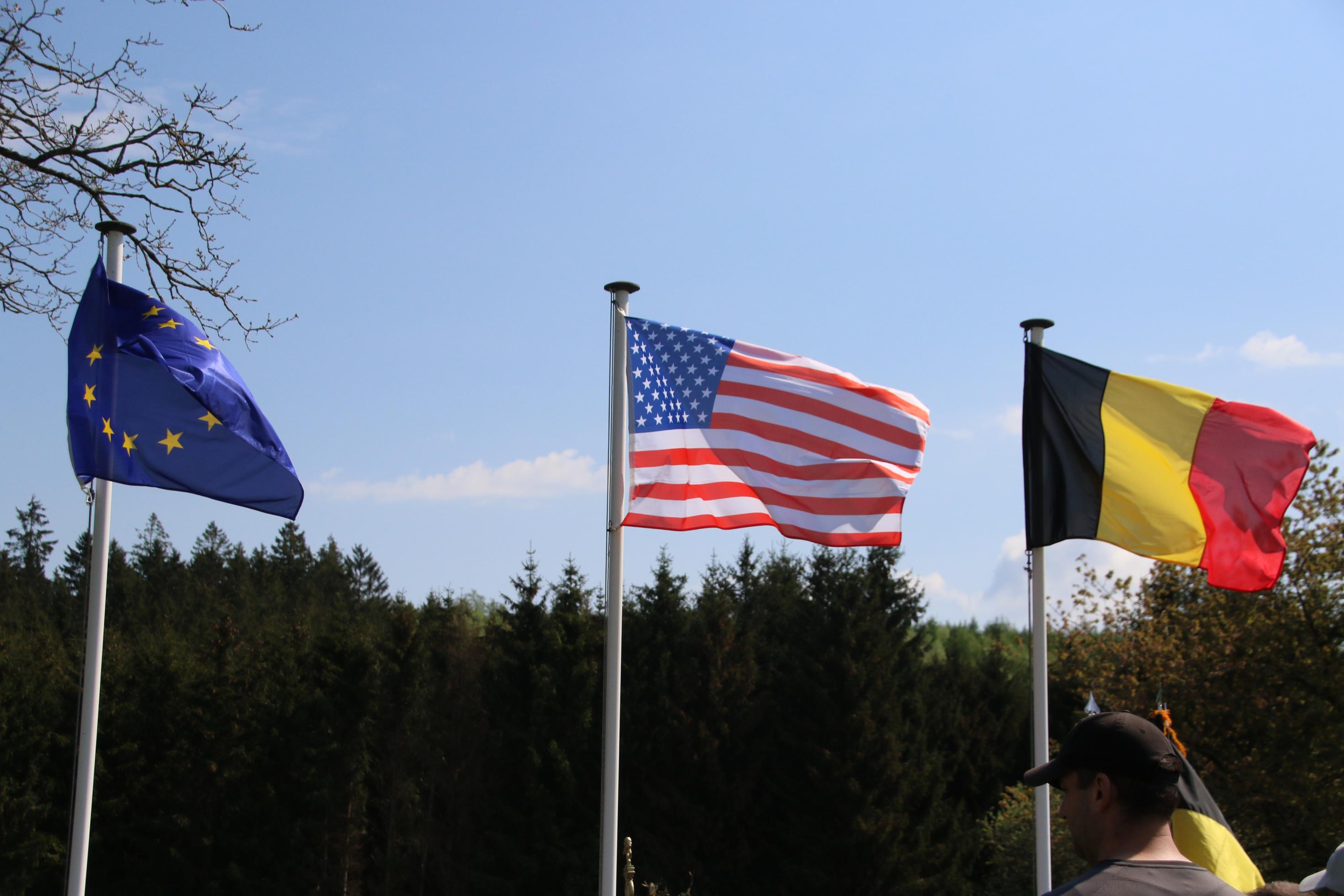 Fahnen der Länder Belgien, USA und der EU wehen im Wind.