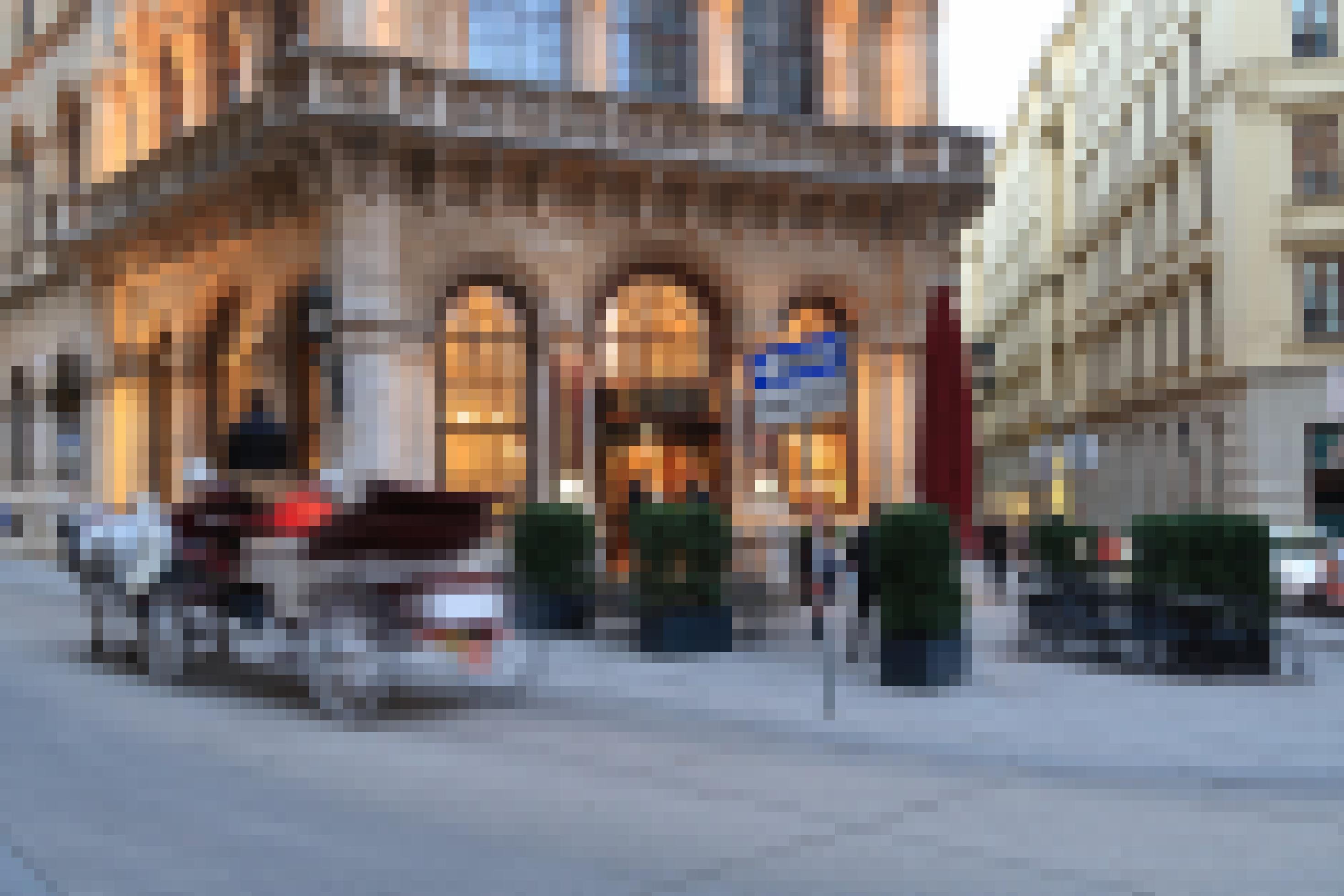 Eine Pfedekutsche fährt vor einem Kaffeehaus in Wien entlang