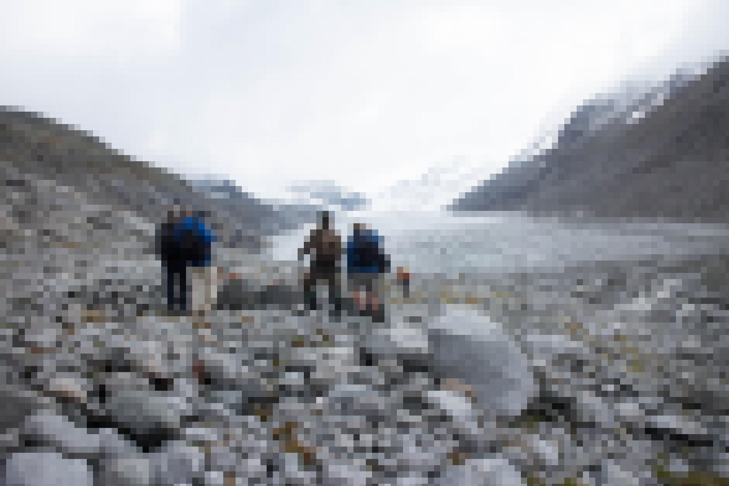 Gletscher, davor Gletschervorfeld mit Steinen, Wanderer.