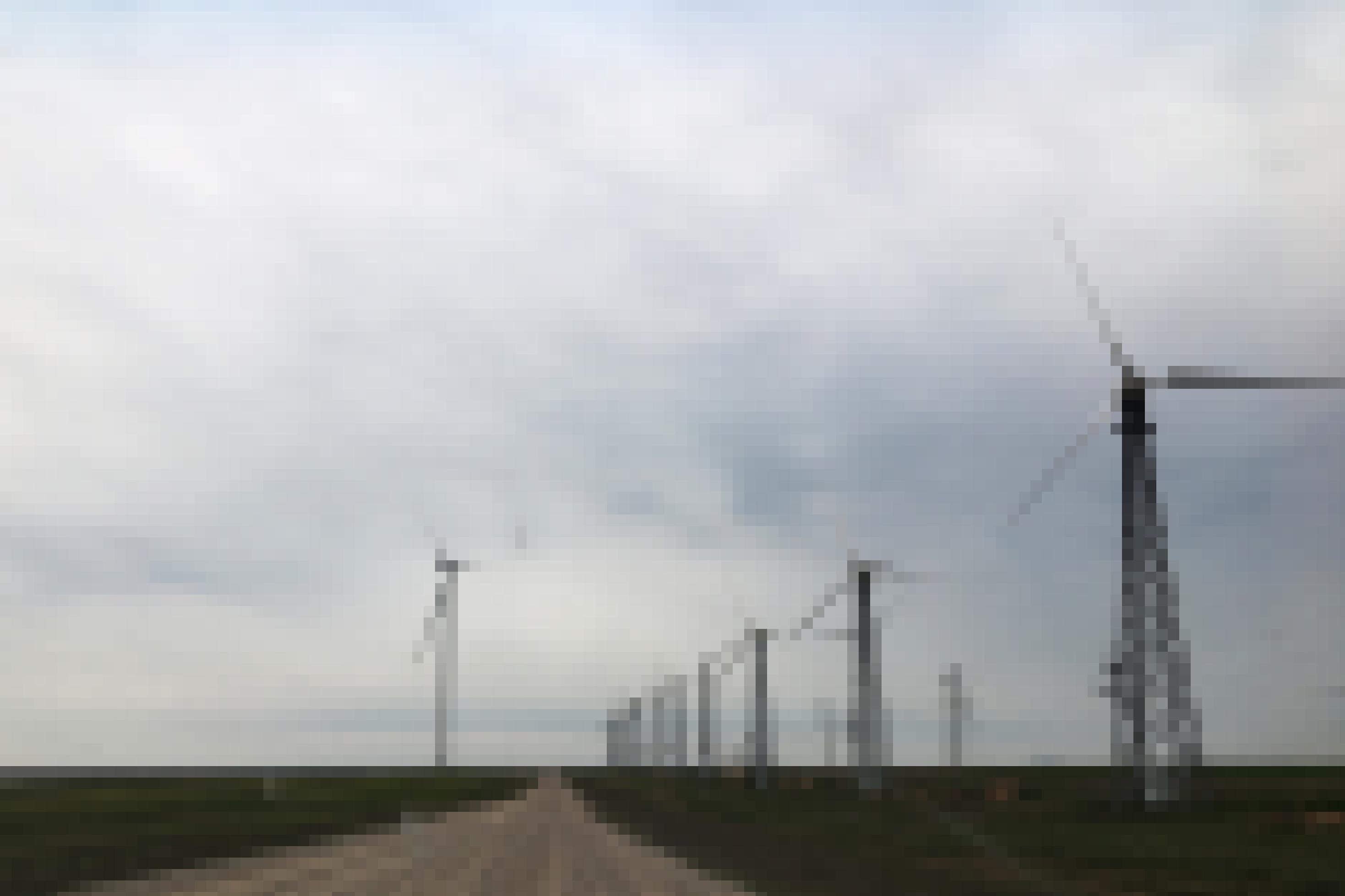 Windkraftanlage mit einer Reihe an einer Straße aufgereihten Windrädern