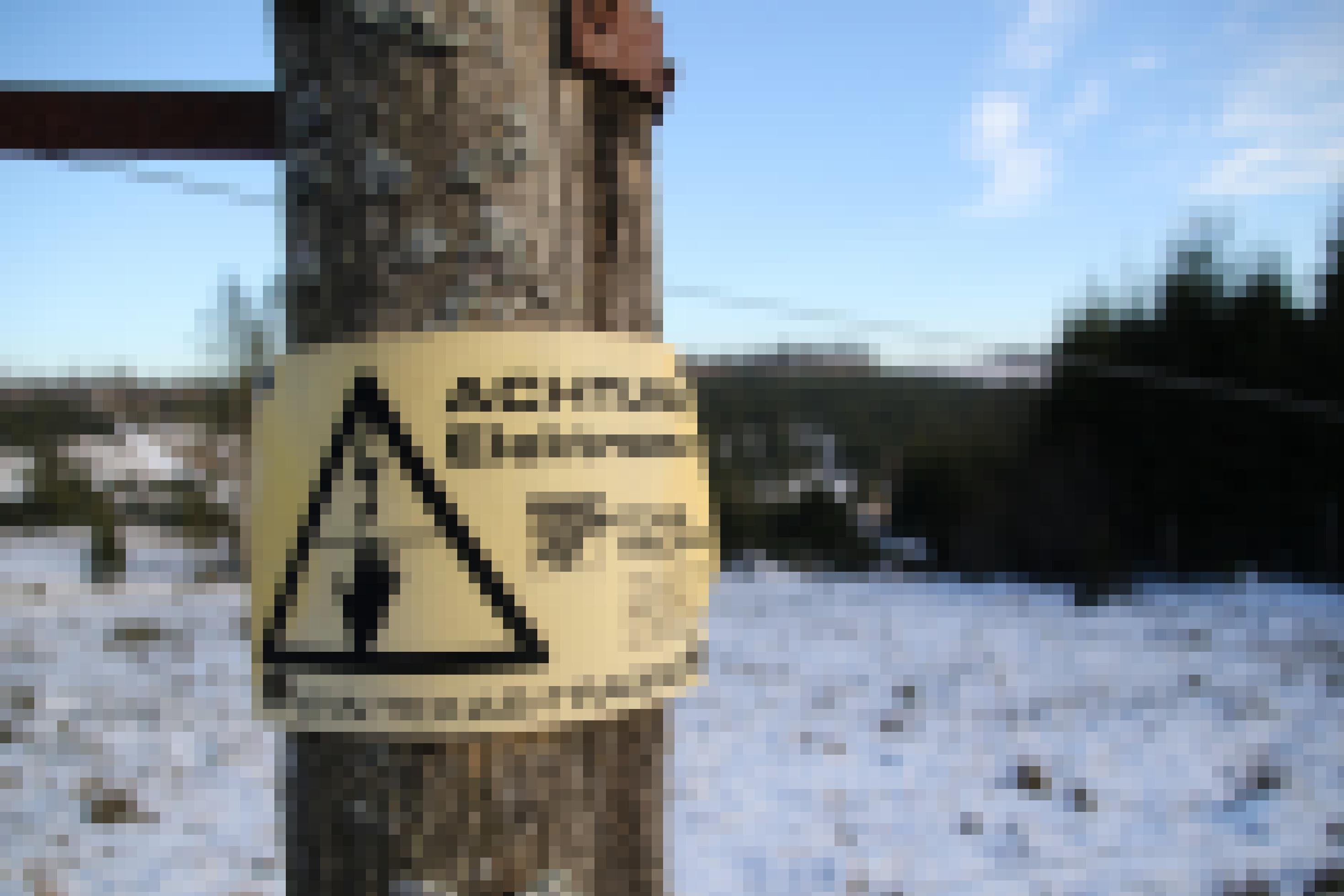 Schild am Elektrozaun warnt vor Hochspannung