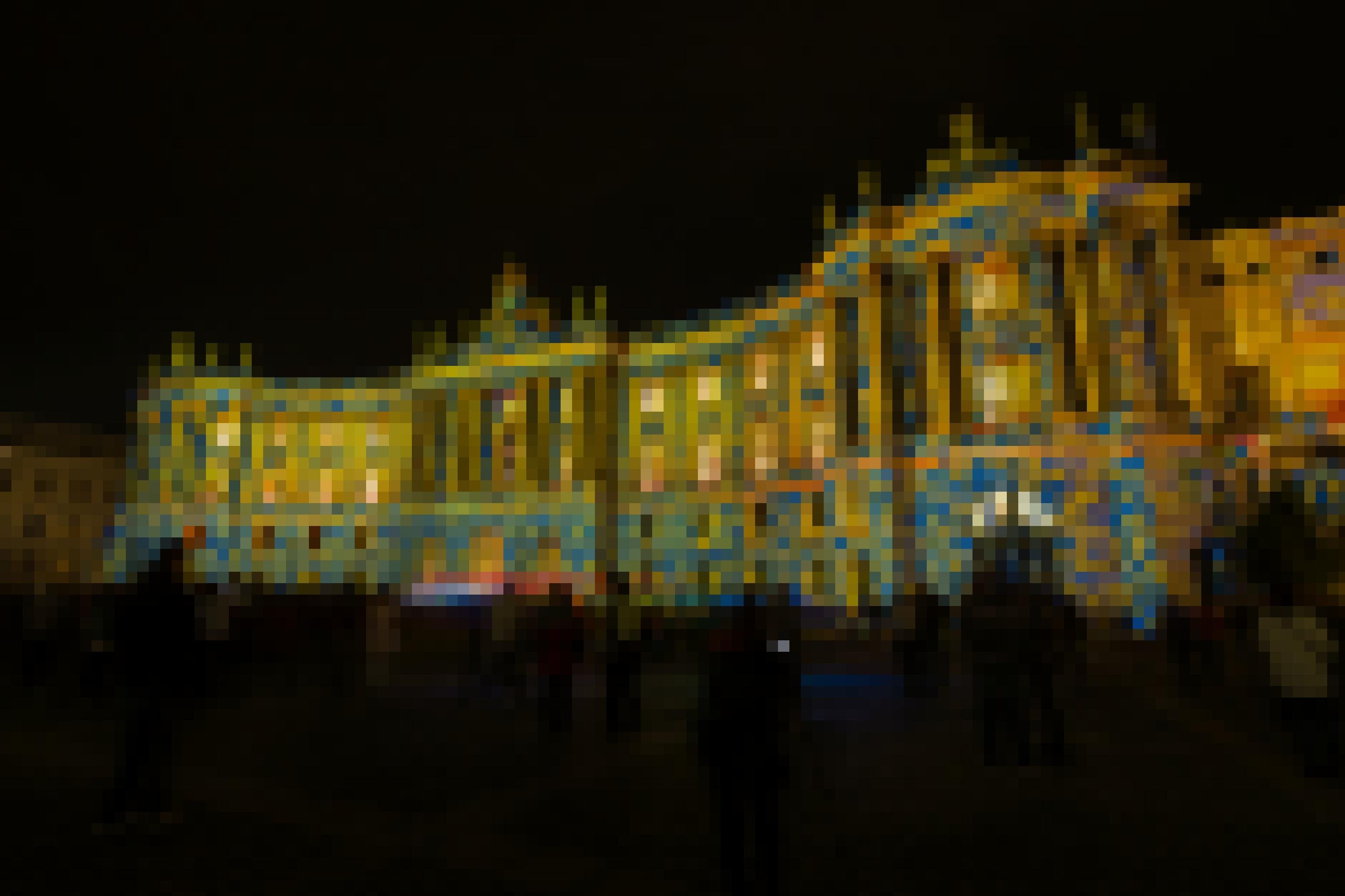 Die Humboldtuni bei Nacht, bestrahlt von Scheinwerfern, die Blumenmuster auf die Fassade projizieren.