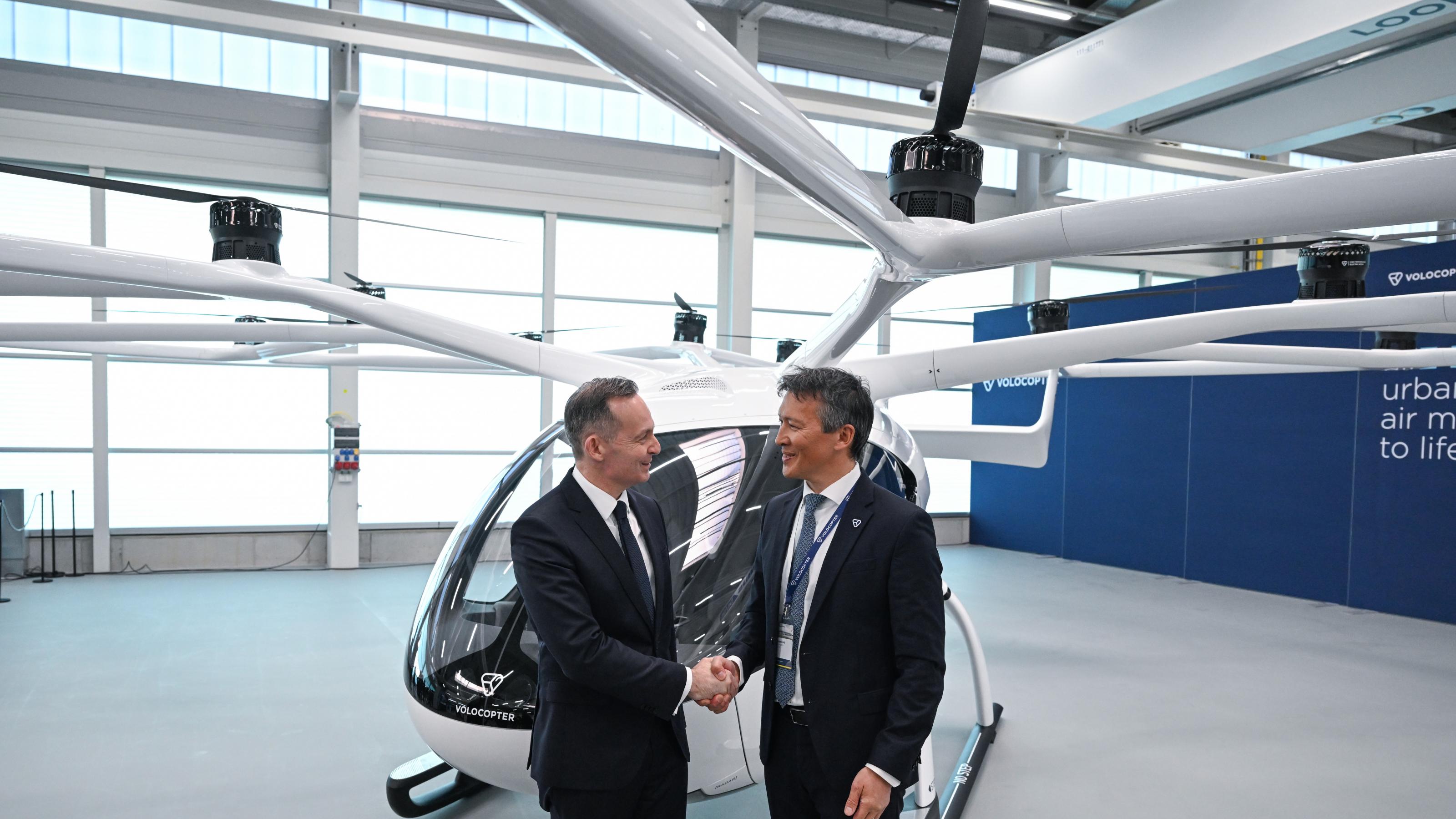 Volker Wissing (FDP, l), Bundesminister für Verkehr und Digitales, und Dirk Hoke ®, Geschäftsführer von Volocopter, schütteln sich bei der Eröffnung eines Hangars für elektrisch angetriebene Flugtaxen Volocopter die Hände.