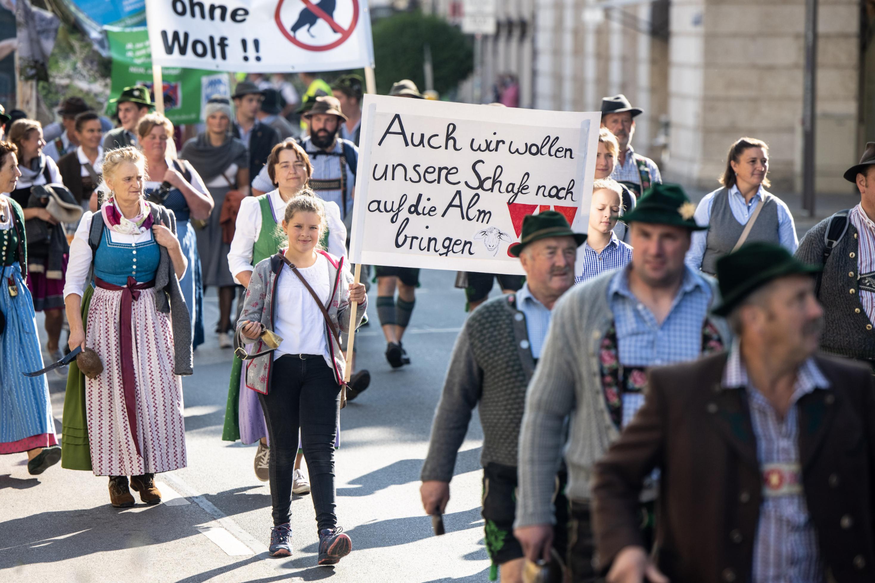 Zwei Mädchen tragen während eines Demonstrationszugs durch die Innenstadt vom Bayerischen Bauernverband unter dem Motto „Ausgebimmelt? Gemeinsam für den Schutz der Weidetiere“ ein Schild mit der Aufschrift „Auch wir wollen unsere Schafe noch auf die Alm bringen“. Thema der Demonstration ist die Rückkehr der Wölfe in den Alpenraum, der Weidetierhalter, Schäfer und Bergbauern vor Probleme stellt.