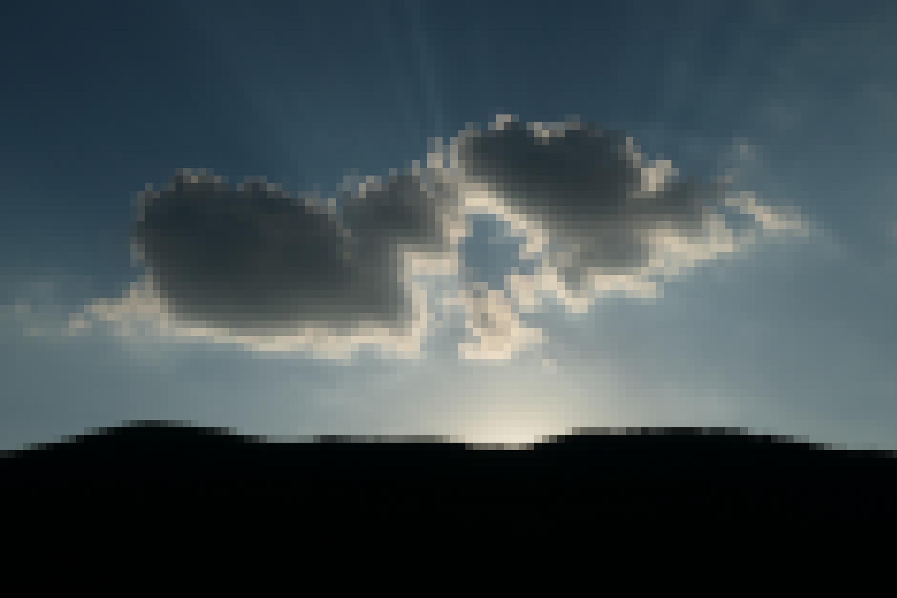 Das Foto zeigt die schwarze Silhouette eines Bergmassivs im Gegenlicht der gerade dahinter verschwundenen Sonne. Darüber erstreckt sich der tiefblaue Himmel, vor dem eine graue, an ihren Rändern hell angeleuchtete Wolke schwebt. Dort, wo die Sonne hinter dem Bergmassiv liegt, ist es gleißend hell und einige Strahlen der Sonne erstrecken sich von diesem Punkt aus in den Himmel. Viele Menschen werden von solchen Naturschauspielen berührt und manche fragen sich, ob da noch mehr existiert, als wissenschaftlich erklärbar ist.