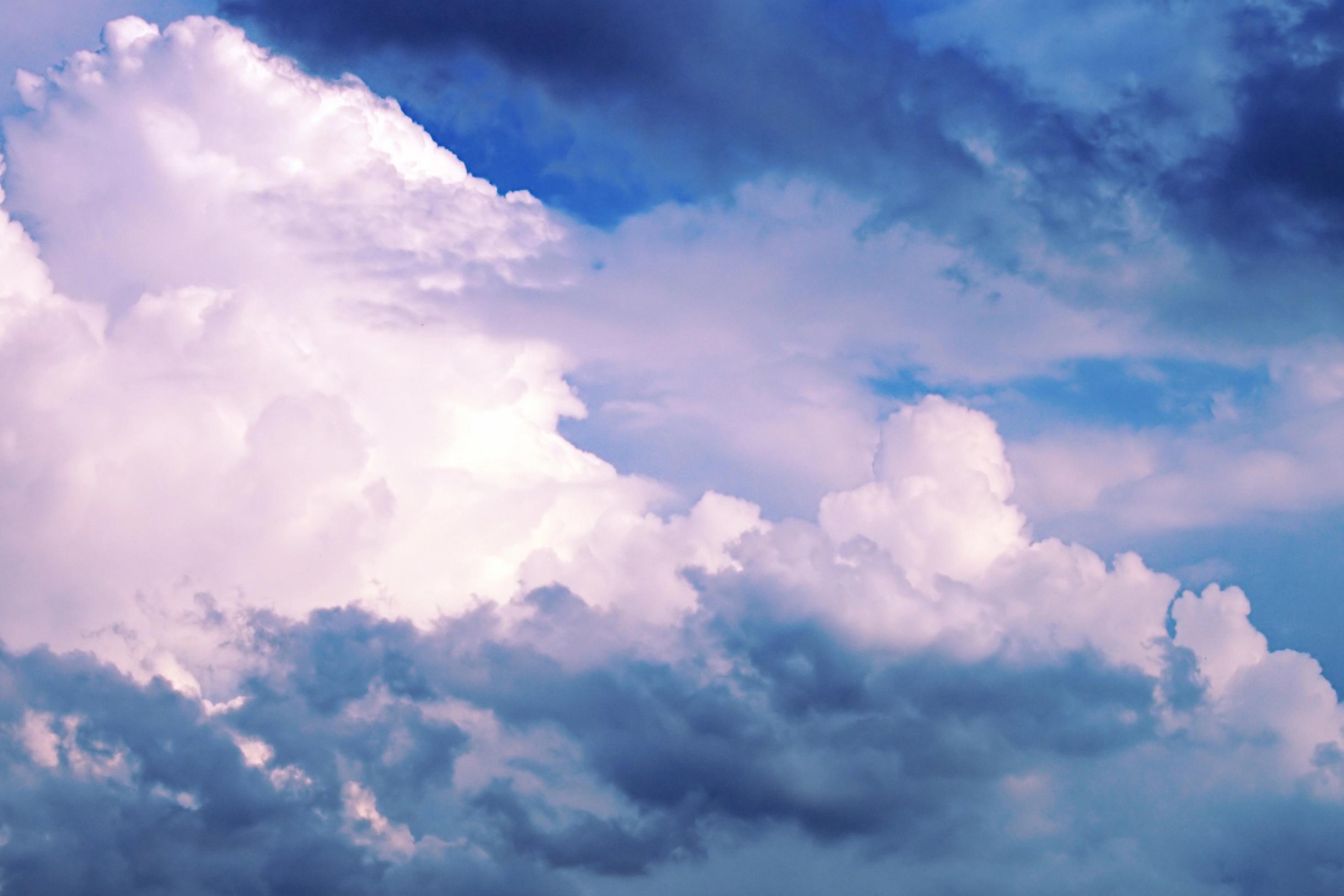 Ein Wolkenbild, schweren dunkle und weiße Kumulus-Wolken, teilweise von der Sonne bestrahlt..