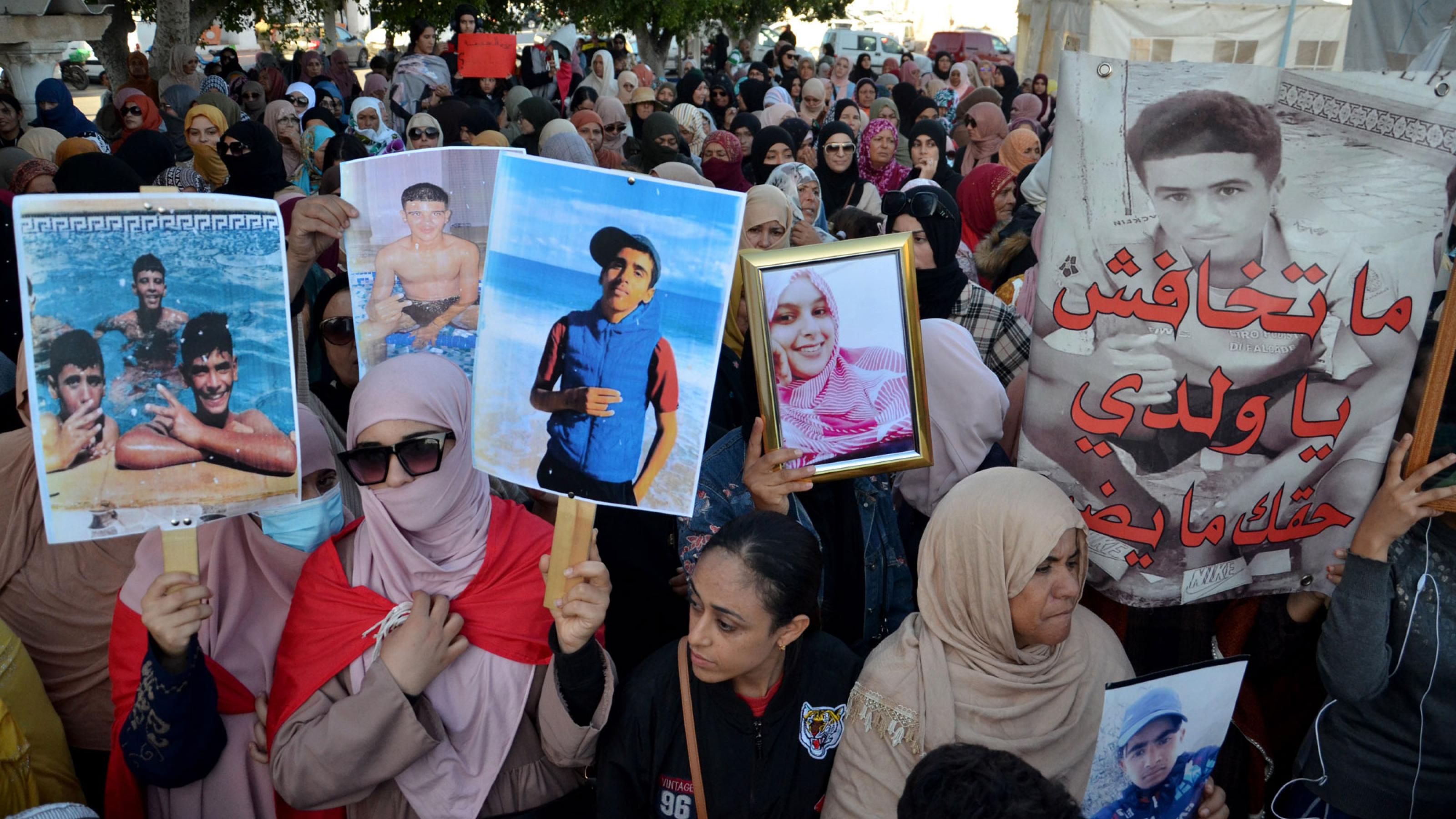Eine Demonstration, bei der die Menschen in der ersten Reihe Plakate mit Slogans und Bilder Vermisster und Verstorbener hochhalten